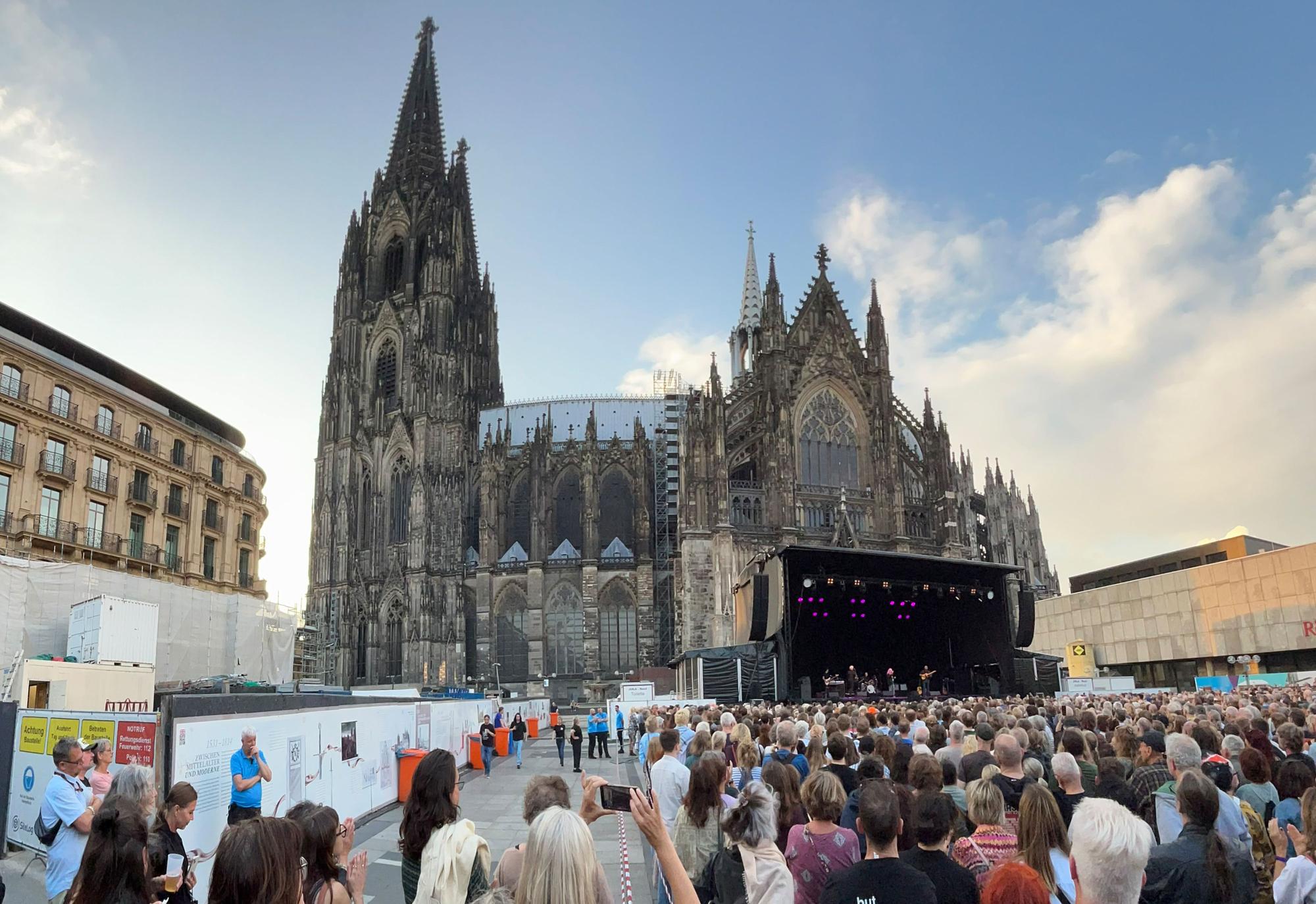 Vor der Südfassade des Doms stehen die Besucher des Patti-Smith-Konzerts am 25. Juli 2025.