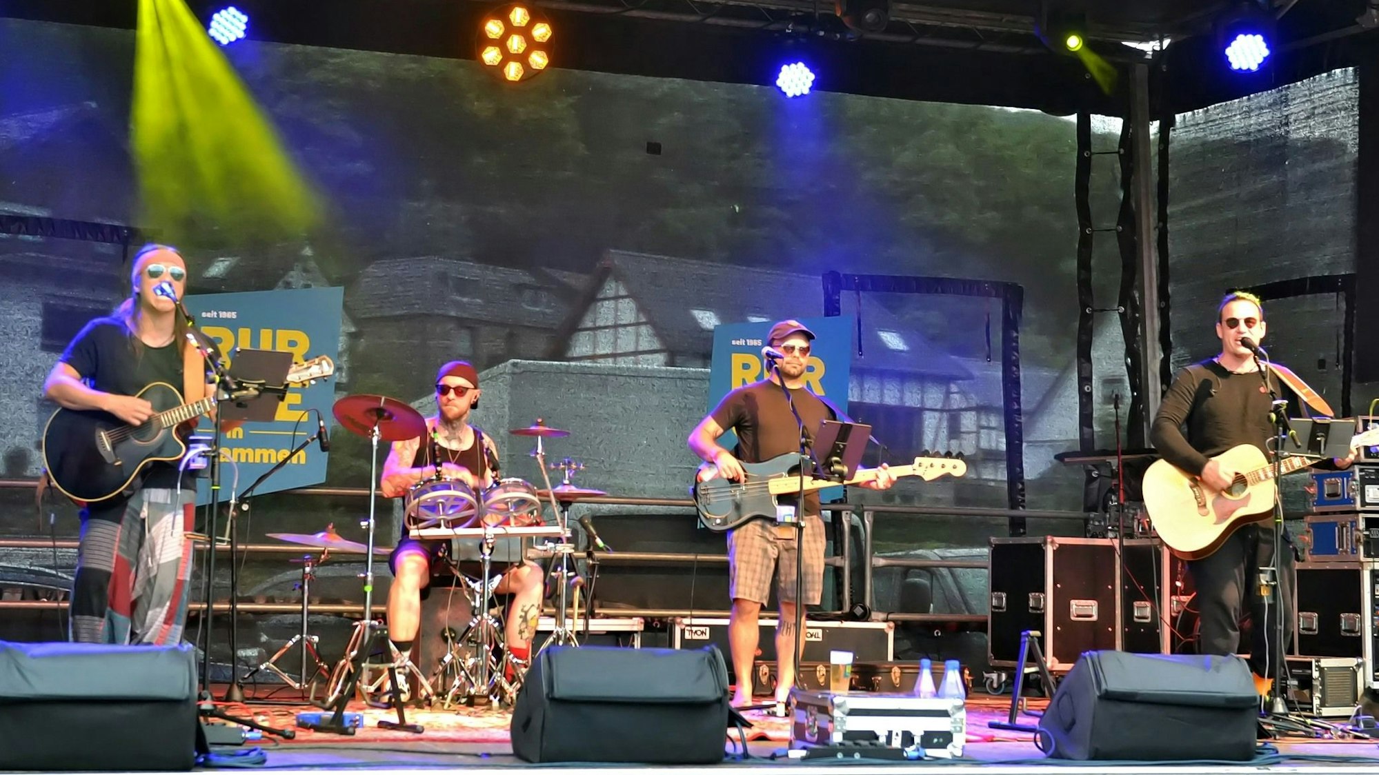 Auf der Bühne musizieren die vier Mitglieder der Band „Colour the Sky“.