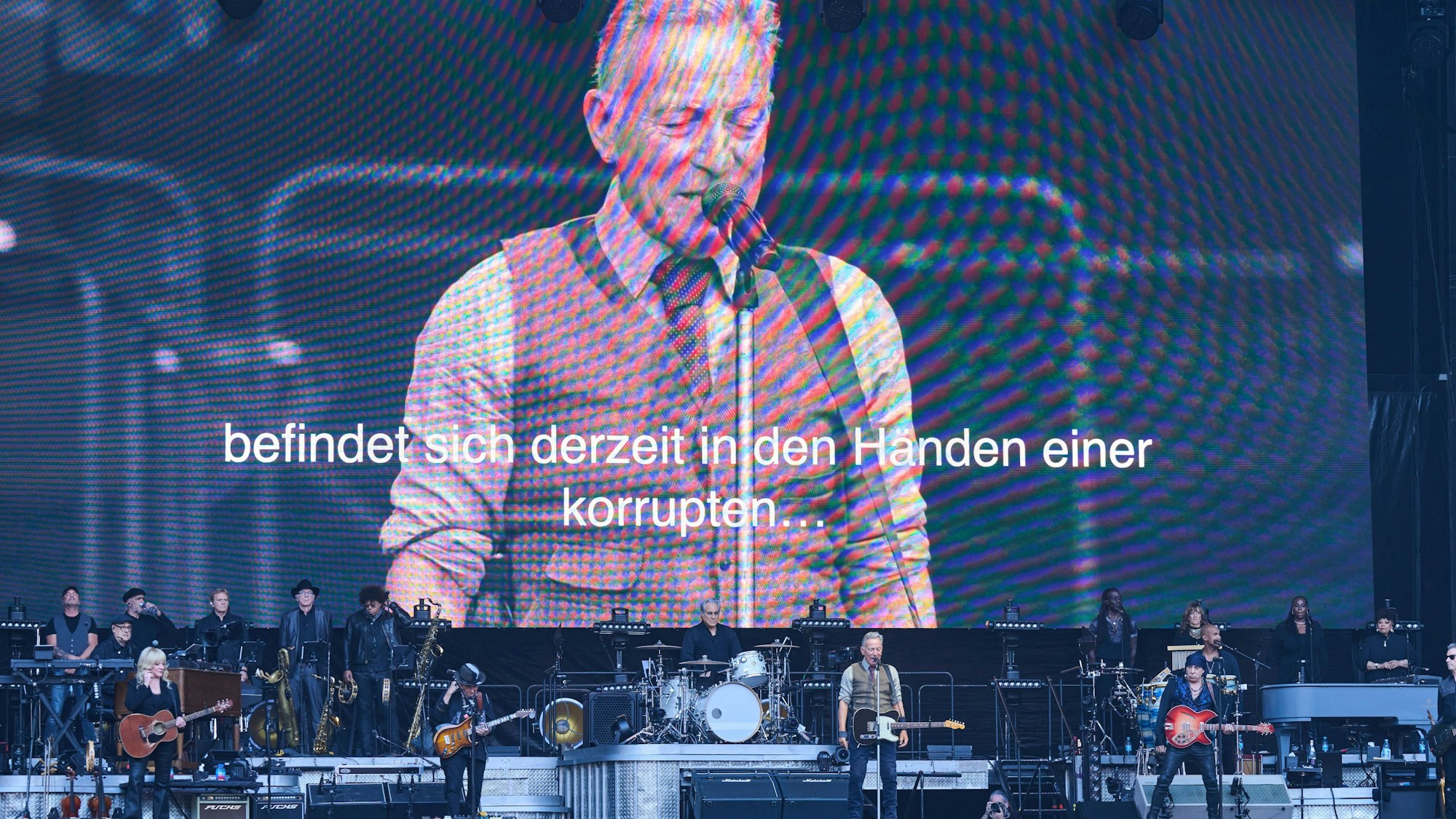 11.06.2025, Berlin: Während des Konzerts von Bruce Springsteen and The E Street Band im Olympiastadion läuft folgender Text über die Großbildleinwand: «Das Amerika, das ich liebe, über das ich für Euch geschrieben habe, das seit 250 Jahren ein Leuchtturm der Hoffnung und der Freiheit ist, befindet sich derzeit in der Händen einer korrupten, inkompetenten und verlogenen Regierung. Heute Abend bitten wir alle, die an die Demokratie und an das Beste glauben, ihre Stimme zu erheben und die Freiheit erklingen zu lassen.» Foto: Annette Riedl/dpa +++ dpa-Bildfunk +++