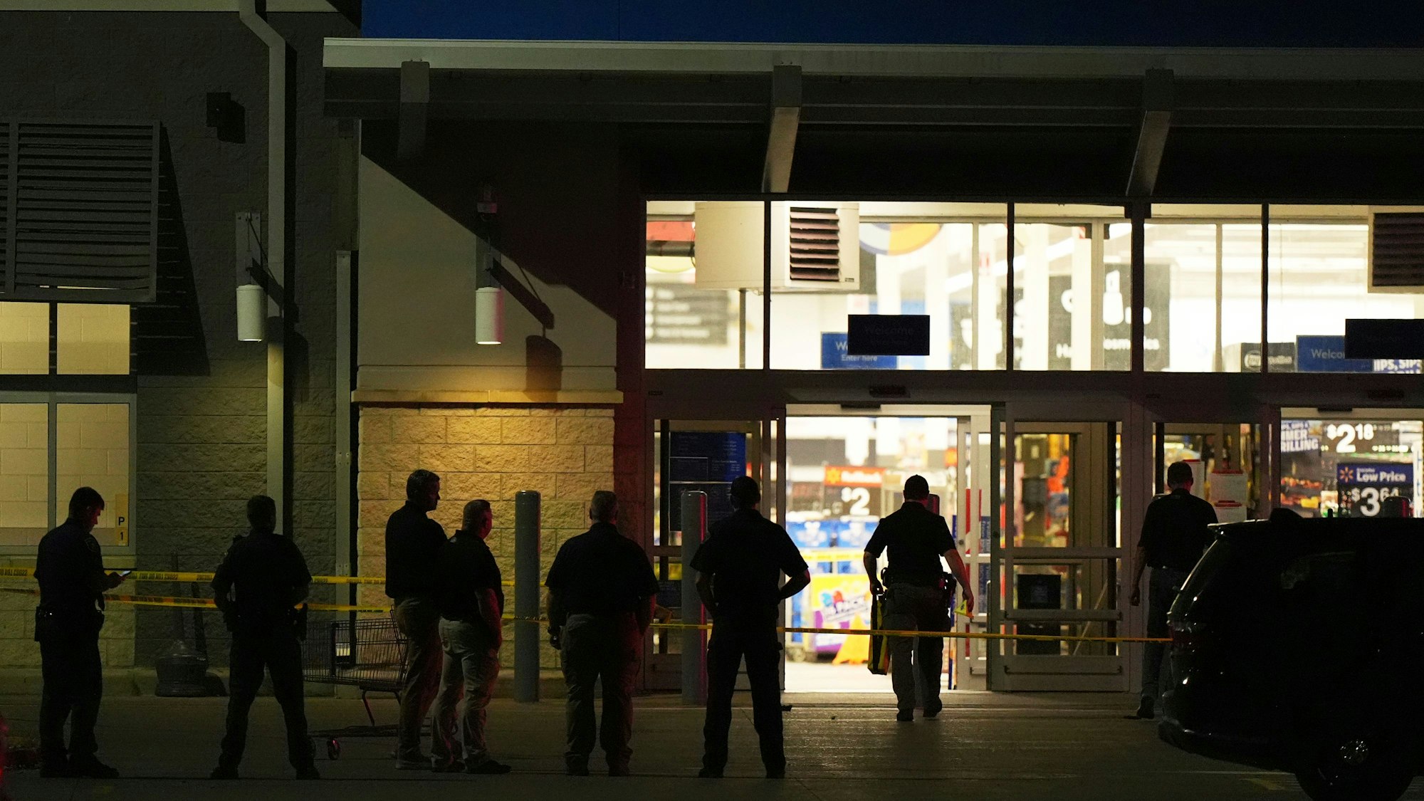 27.07.2025, USA, Traverse City: Polizeibeamte stehen vor einem Walmart, in dem in Traverse City, Michigan, 11 Menschen niedergestochen wurden. Foto: Ryan Sun/STF/dpa +++ dpa-Bildfunk +++