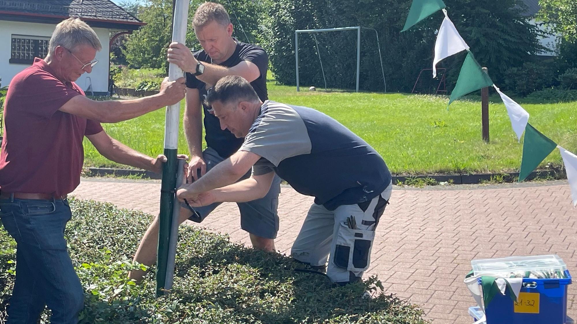 Mit vereinten Kräften fürs Fest: In Müllenbach schmücken Jung und Alt gemeinsam die Straßen und setzen etwa die Wimpelmasten.