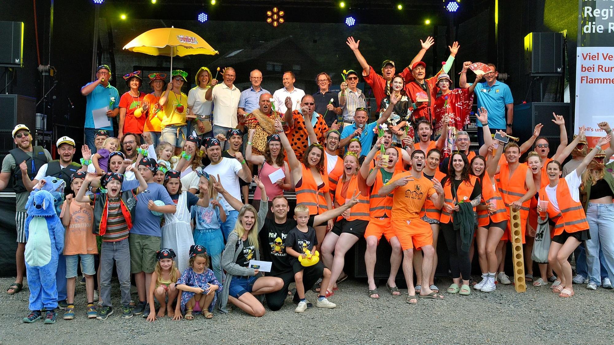 Auf dem Gruppenfoto sind die Teilnehmer der Crazy-Boats-Parade zu sehen, die sich passend zu ihren fantasievollen Booten verkleidet hatten.
