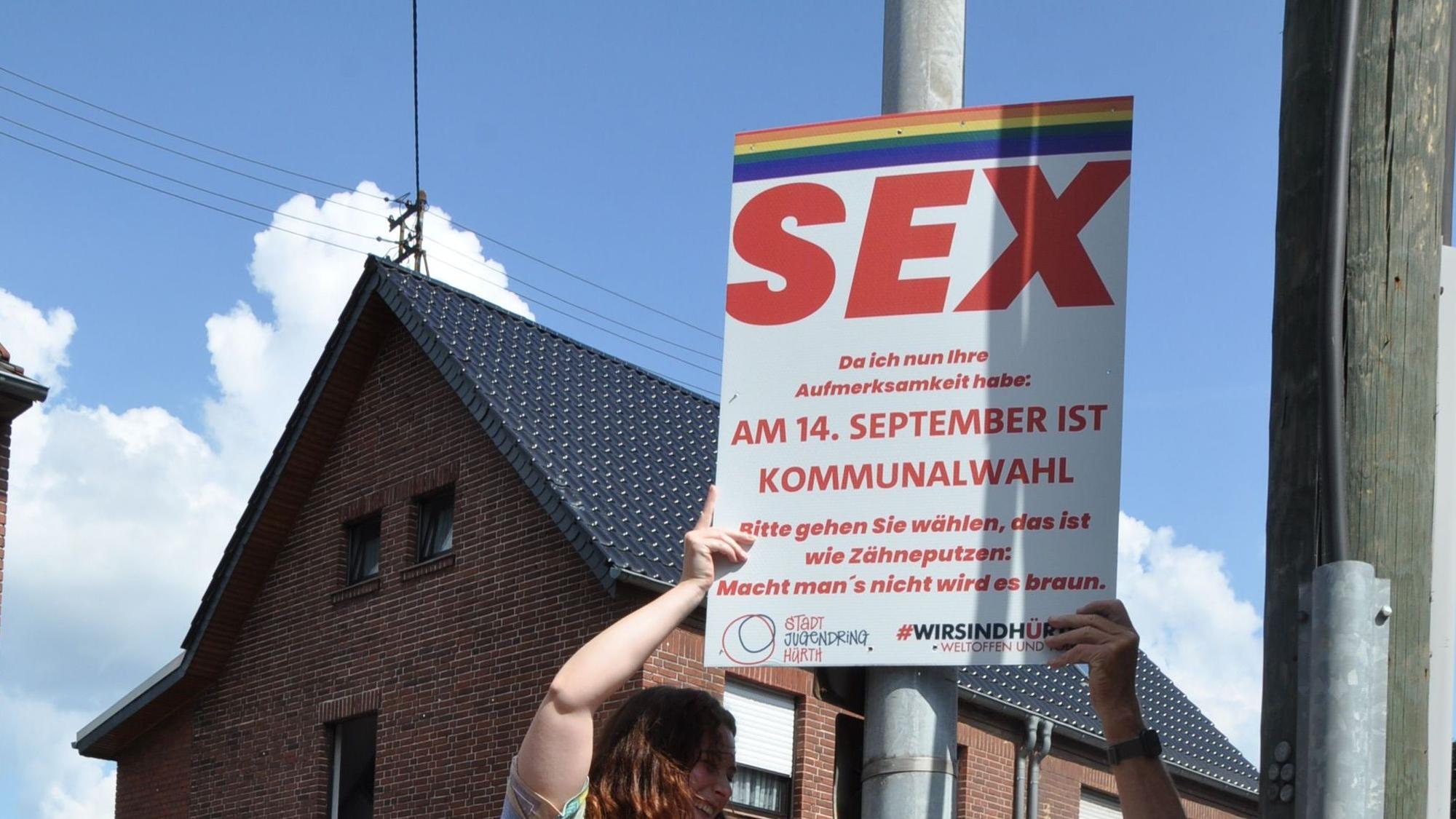 Auf dem Plakat ist groß „Sex“ zu lesen und darunter deutlich kleiner „Da ich nun Ihre Aufmerksamkeit habe: Am 14. September ist Kommunalwahl. Bitte gehen Sie wählen, das ist wie Zähneputzen: Macht man's nicht, wird es braun.“