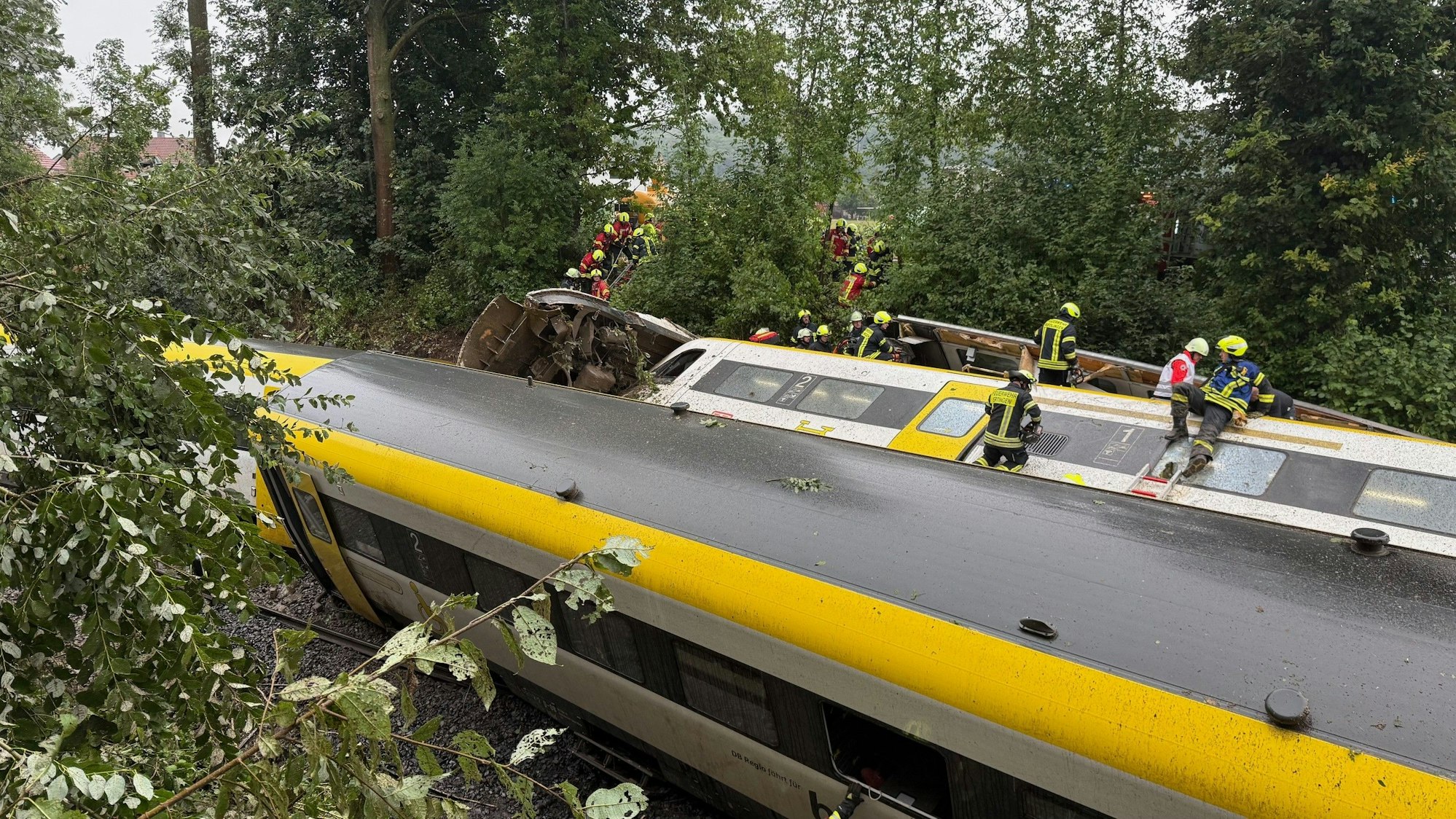 Rettungskräfte suchen in einem entgleisten Zug nach Fahrgästen.