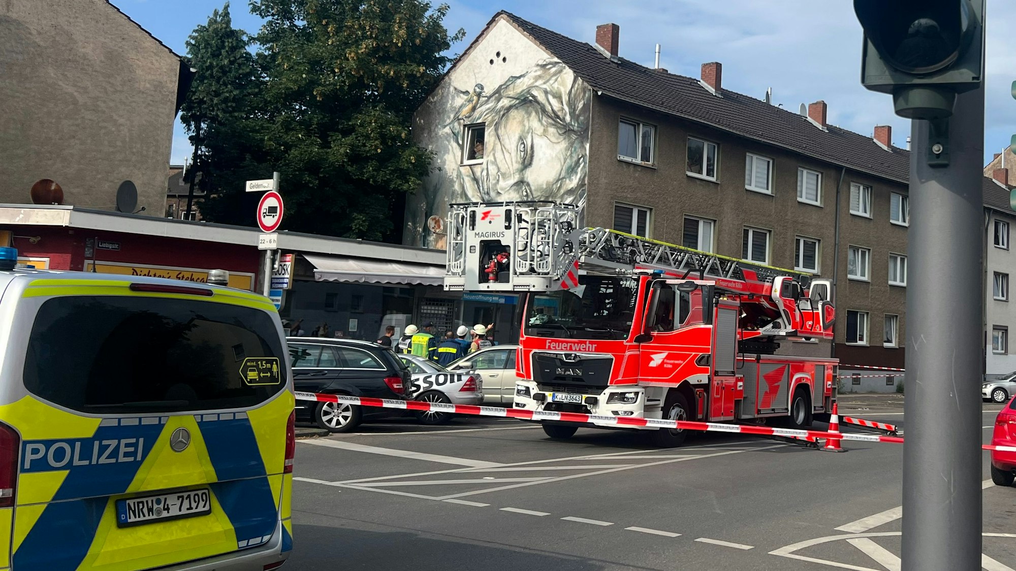 Die Kölner Feuerwehr steht in der Liebigstraße mit einem Löschfahrzeug und einer Drehleiter vor einem leerstehenden Haus, in dem der Dachstuhl eingestürzt ist.