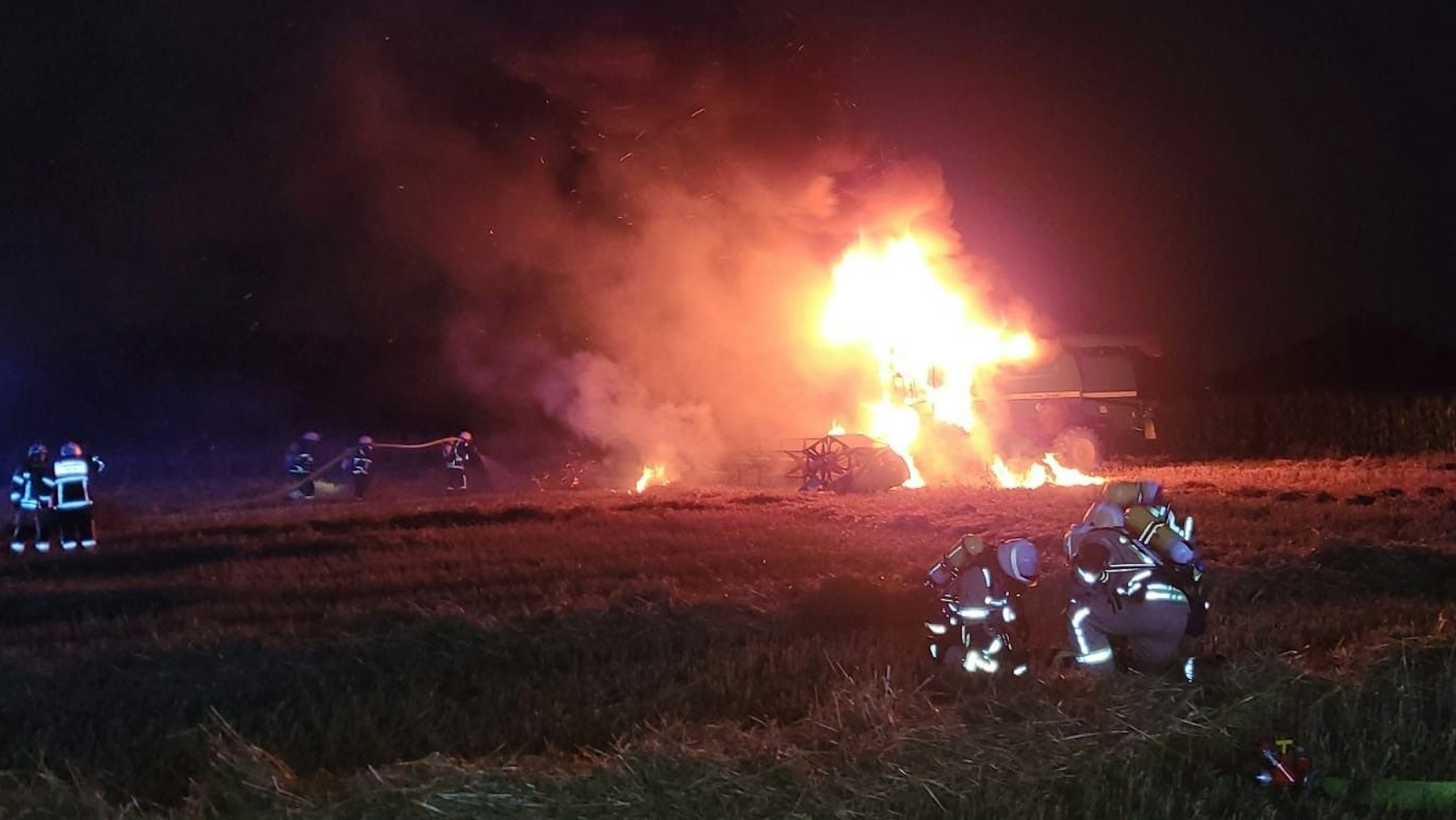 Ein Mähdrescher steht in Köln-Merkenich in Flammen – die Feuerwehr kämpft stundenlang gegen das Feuer auf dem abgelegenen Feld.