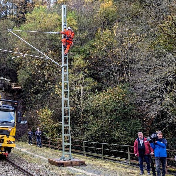 Arbeiter bei der Montage eines Flachmasts mit angelenktem Ausleger am Eingang zum Wilsecker Tunnel bei Kyllburg.