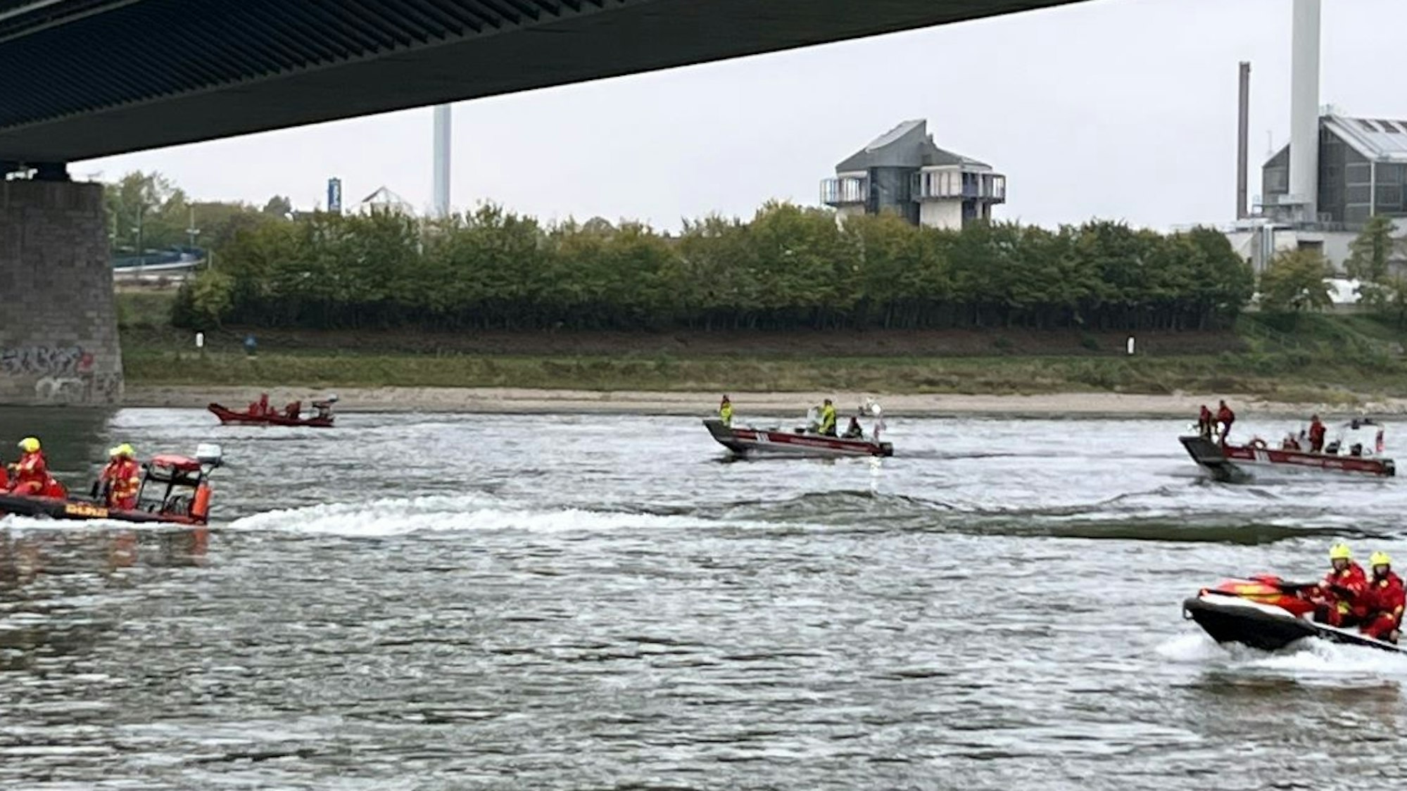 Einsatzkräfte fahren den Rhein mit Booten ab.