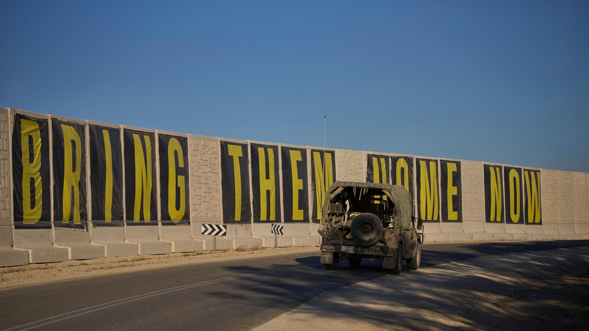 Ein Fahrzeug der israelischen Armee fährt in der Nähe der Grenze zwischen Israel und Gaza mit einem Transparent mit der Aufschrift ‚Bringt sie jetzt nach Hause‘ (Bring them home now), auf dem die Freilassung von Geiseln gefordert wird, die im Gazastreifen von der militanten Hamas-Gruppe festgehalten werden.