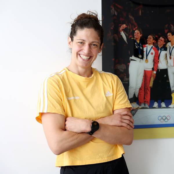 Miriam Butkereit steht vor einem Bild, das sie bei der Siegerehrung der Olympischen Spiele in Paris zeigt.