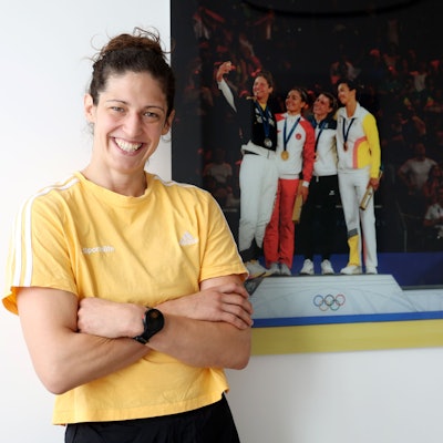Miriam Butkereit steht vor einem Bild, das sie bei der Siegerehrung der Olympischen Spiele in Paris zeigt.