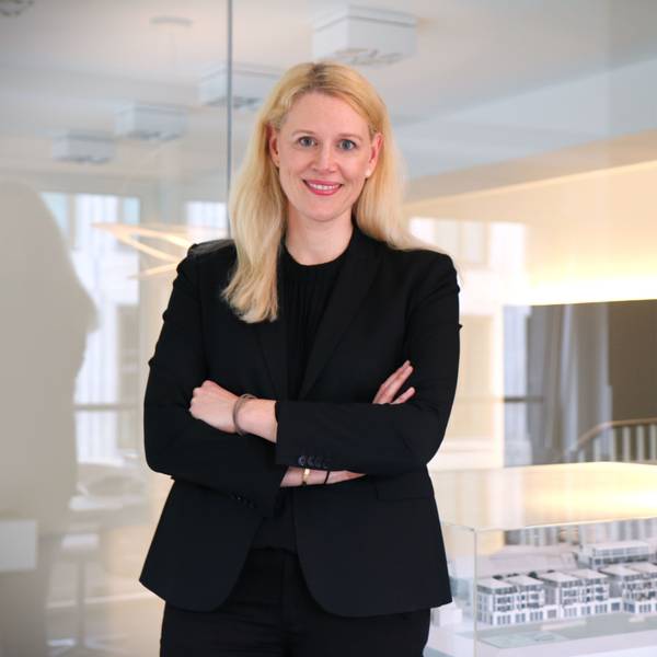 Britta Oebels steht in einem Konferenzraum ihres Hauptgeschäfts am Kaiser-Wilhelm-Ring. Im Hintergrund ein Modell eines Immobilenentwurfs