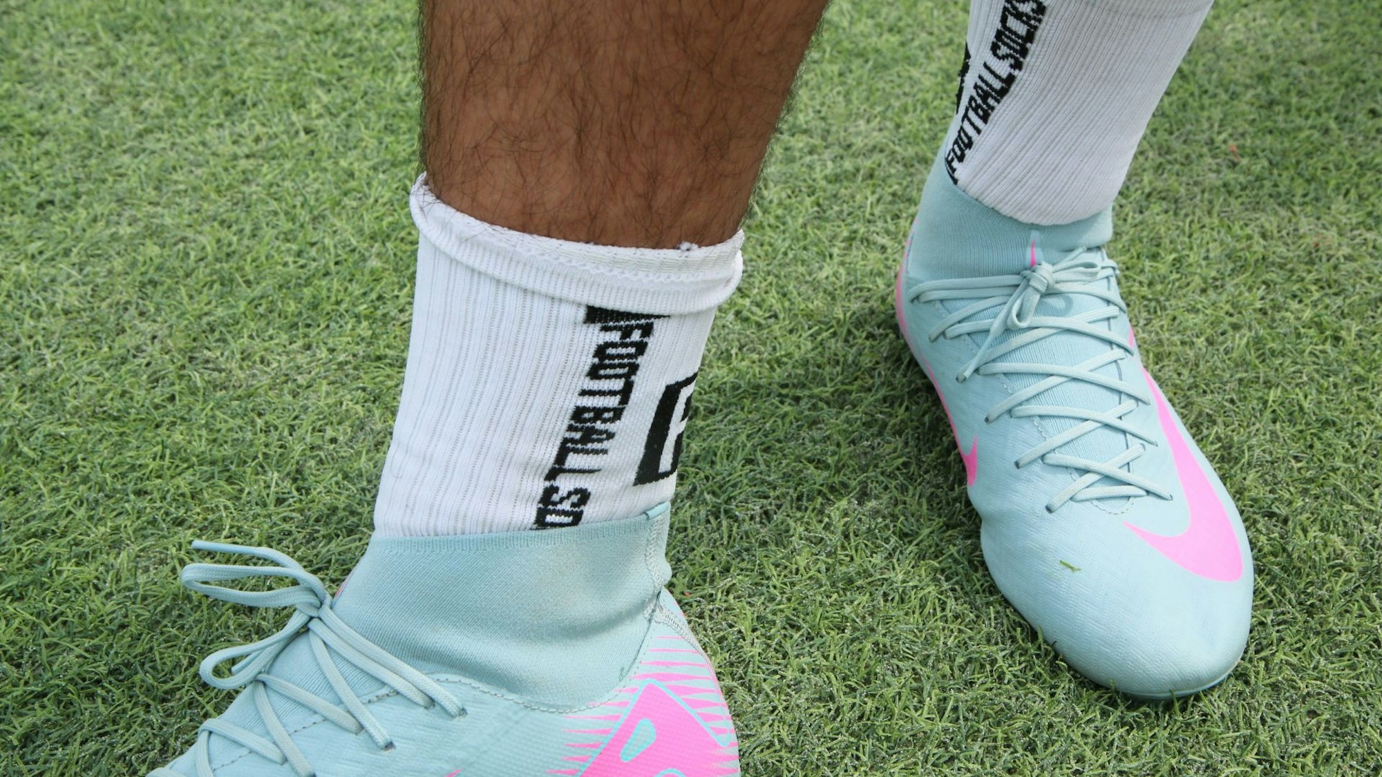 Zu sehen sind zwei Füße, die in Fußballsocken und Fußballschuhen stecken.