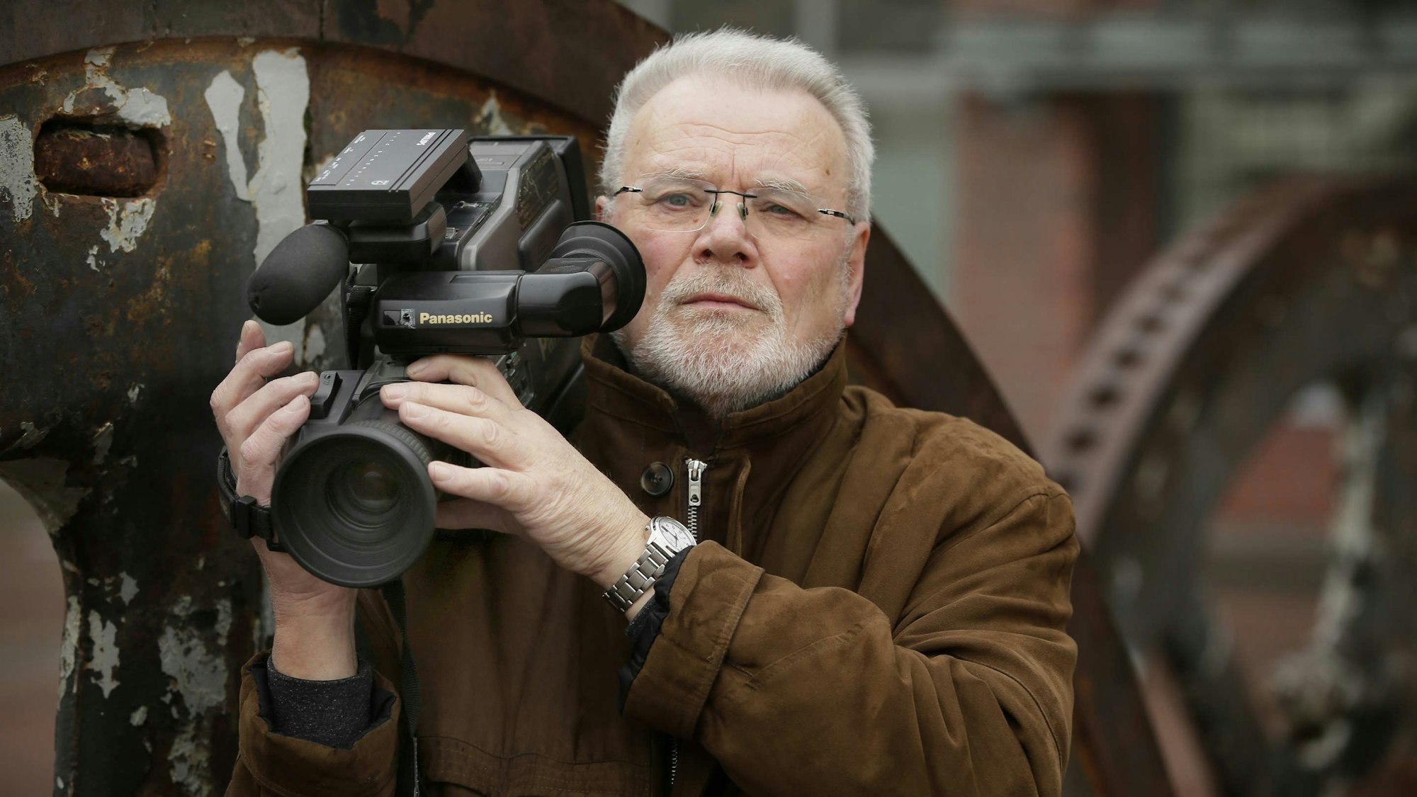 Das Foto zeigt Peter Kleinen, in der Hand eine Kamera.