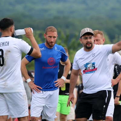 Der Trainer des SV Bessenich, Can Celik, spricht mit seinen Spielern und zeigt mit dem Finger die Richtung an.