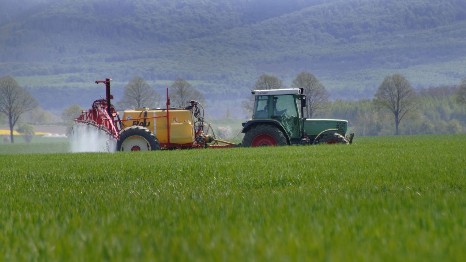 Auf einem Acker in Goeddeckenrode im Landkreis Harz am Nordharz im Bundesland Sachsen-Anhalt bringt ein Landwirt mit Hilfe einer Ackerspritze Pflanzenschutz gegen Schaedlinge auf Winterweizen aus. Pflanzenschutz wird auf Winterweizen ausgebracht.