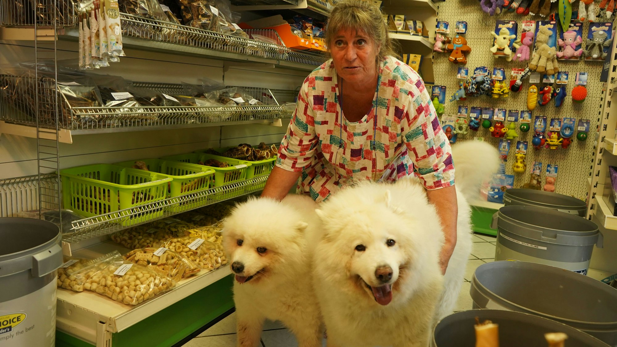 Das Foto zeigt eine Frau mit zwei weißen Hunden.