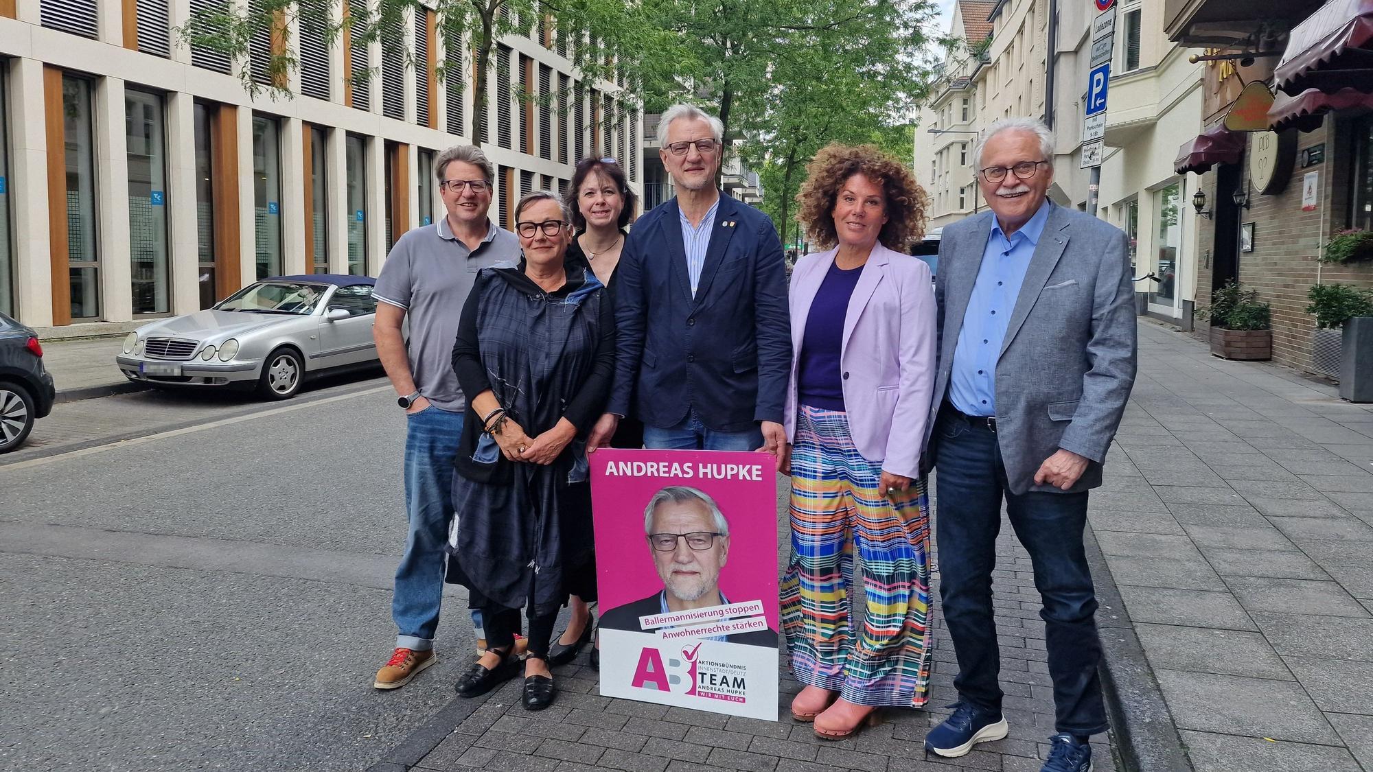 Das Aktionsbündnis von Andreas Hupke posiert mit einem Wahlplakat auf einer Straße in Deutz.