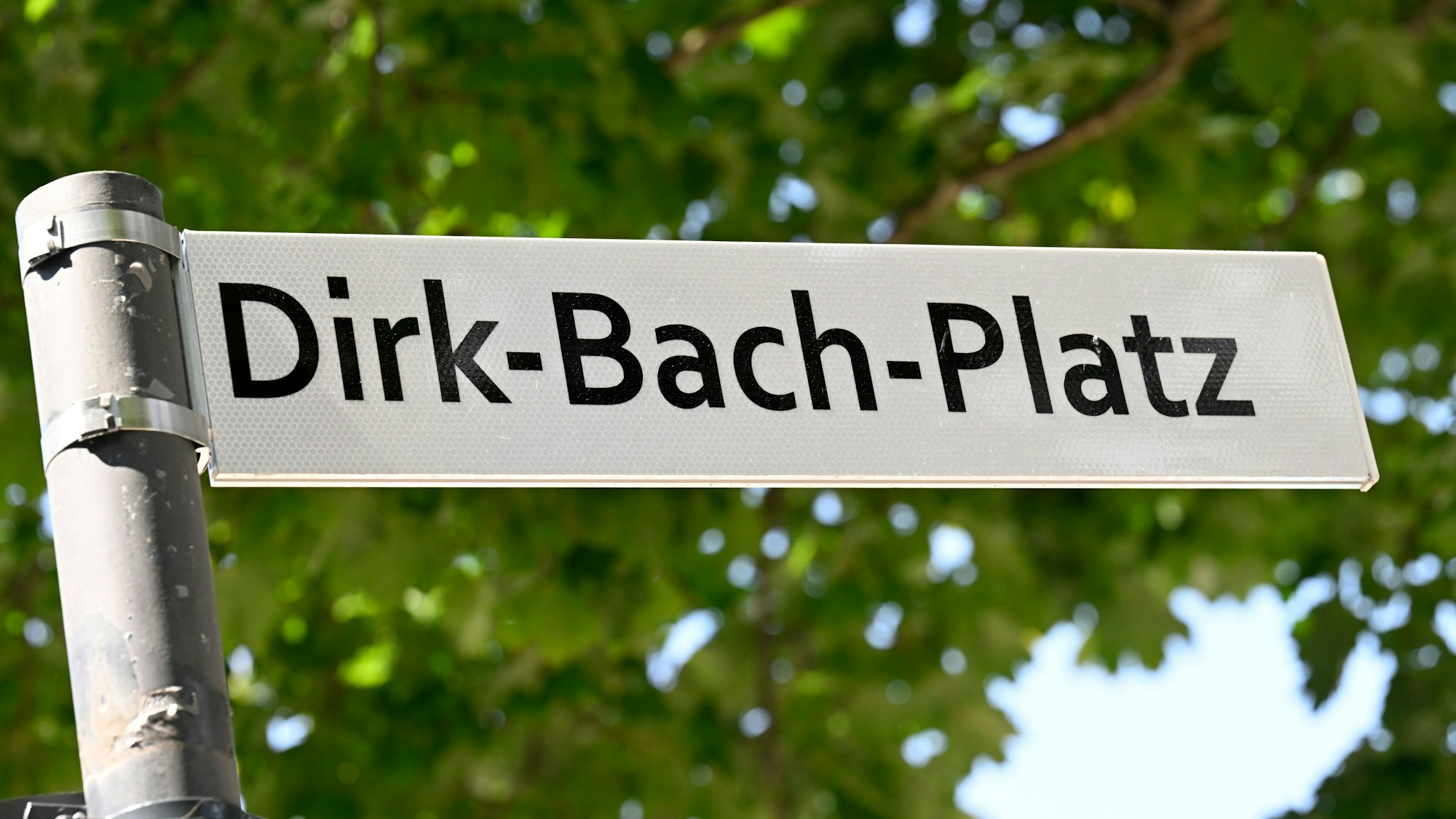 Blick auf das Straßenschild des umbenannten ‚Dirk-Bach-Platz‘ vor dem Schauspielhaus.
