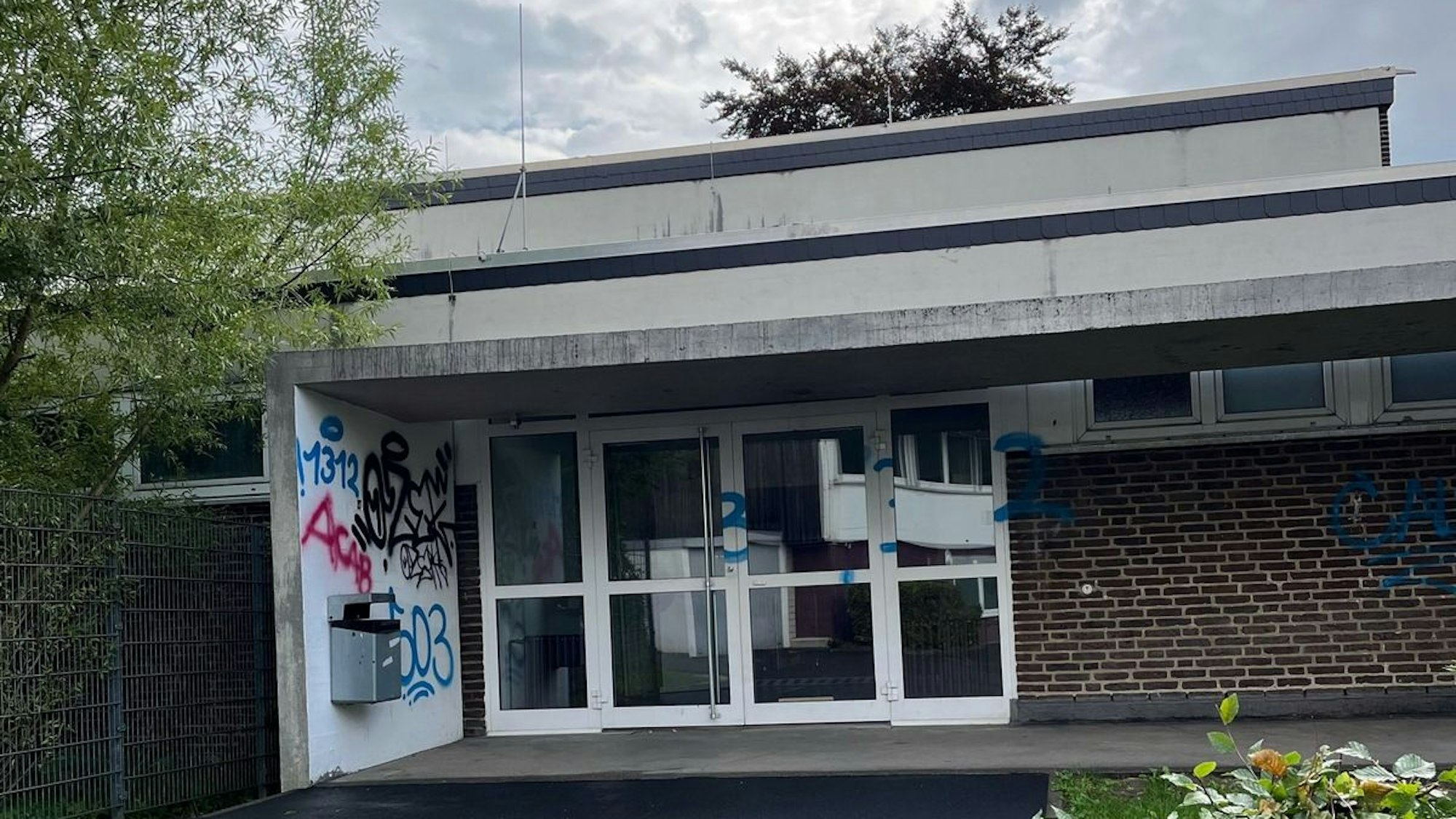 Ein Graffiti an der Fassade eines Schulgebäudes.