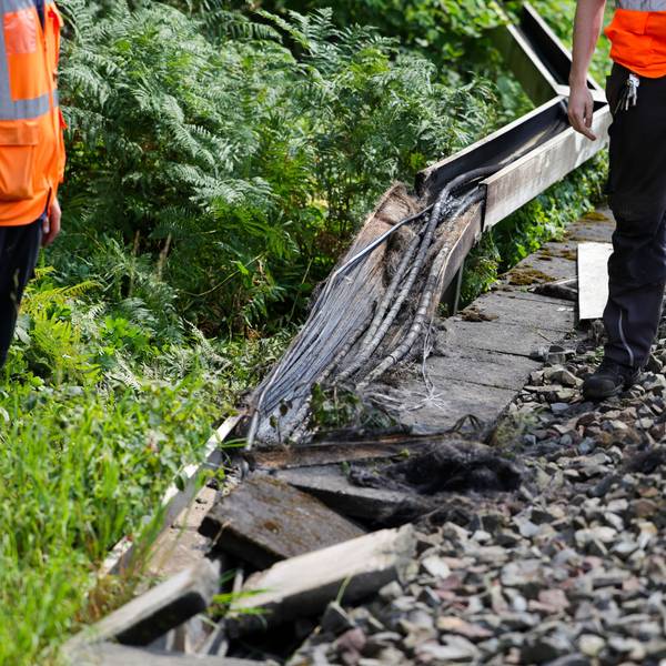 Mitarbeiter der Deutschen Bahn arbeiten an einem Gleisabschnitt in Düsseldorf. Dort wurde neben der Bahnstrecke Feuer in einem Kabeltunnel gelegt, der sechs Kabel in Mitleidenschaft zog. Foto: Christoph Reichwein/dpa