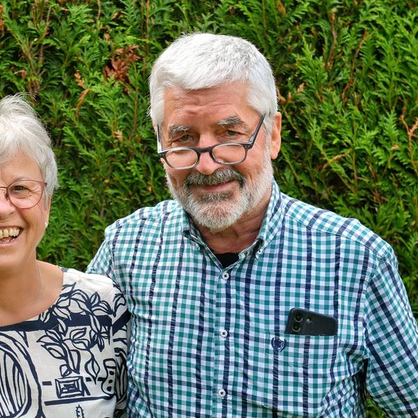 Annegret und Christoph Schmitz stehen vor einer Hecke. Er hat seinen Arm um sie gelegt.