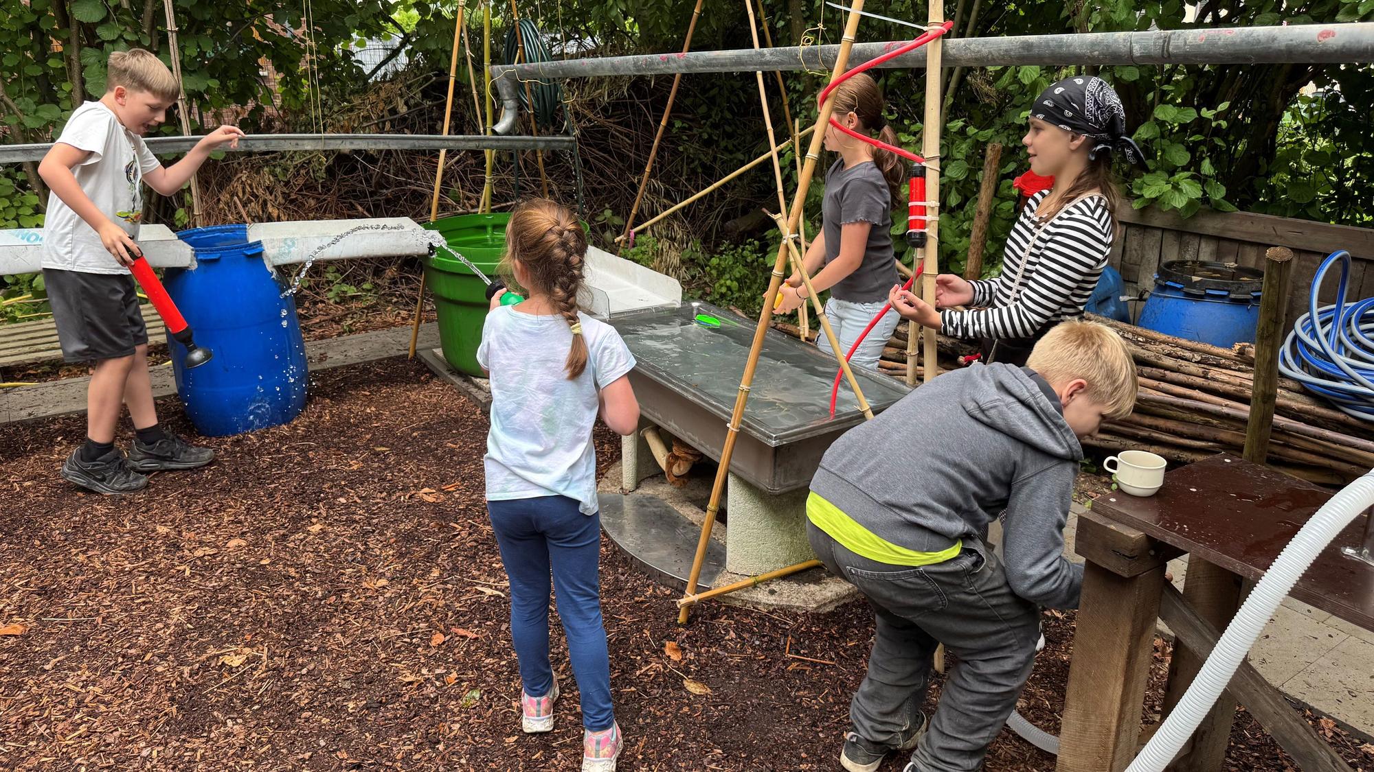 Kinder spielen am neu eröffneten „Wassergarten“ des Jugendzentrum Bunker in Leverkusen Wiesdorf.
