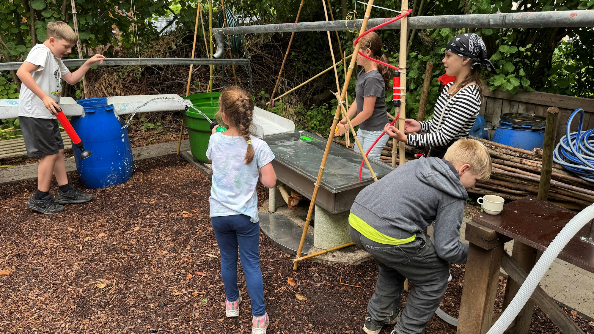 Kinder spielen am neu eröffneten „Wassergarten“ des Jugendzentrum Bunker in Leverkusen Wiesdorf.