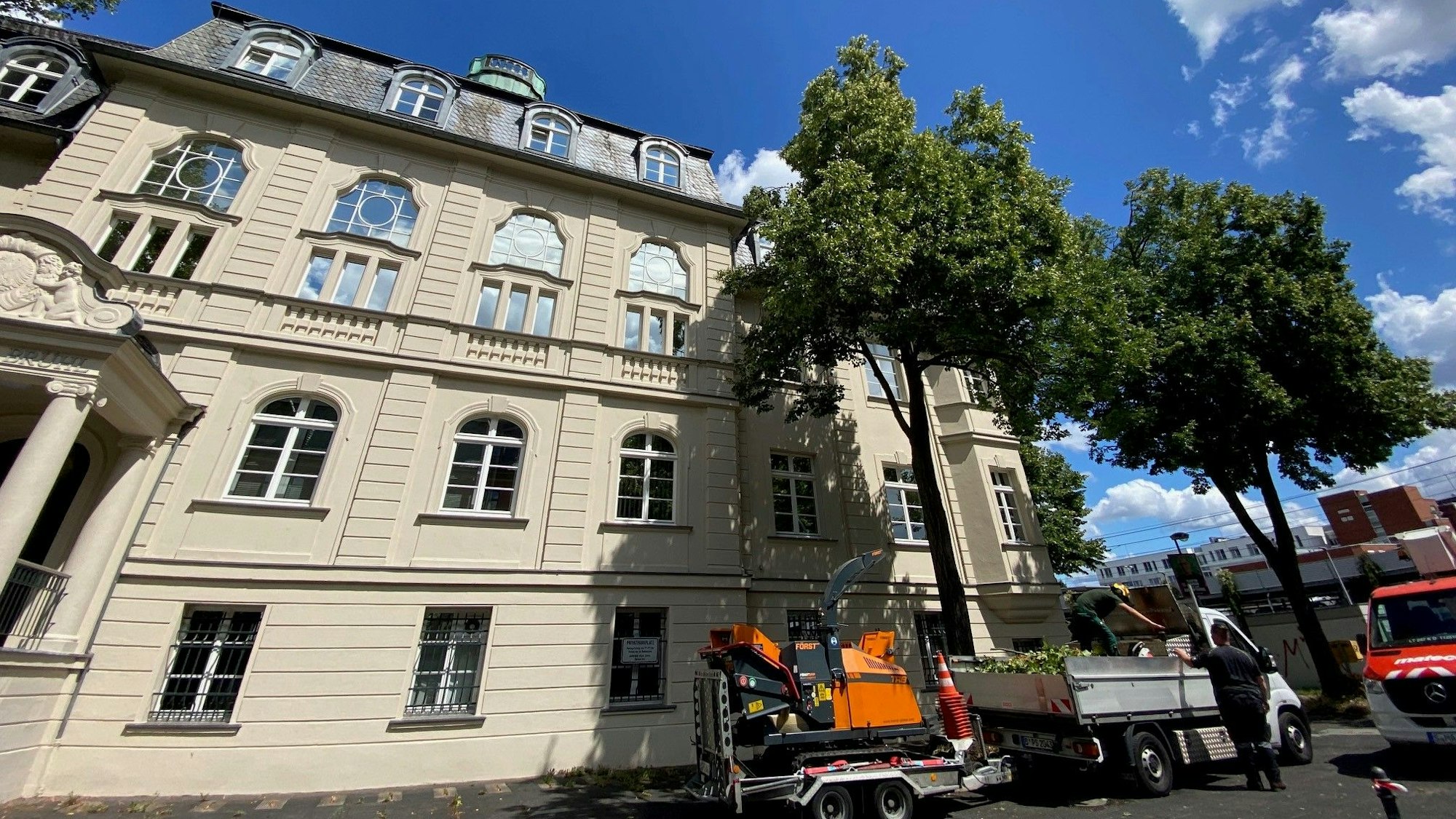 Zu sehen ist ein weißes Haus an einer Straße.