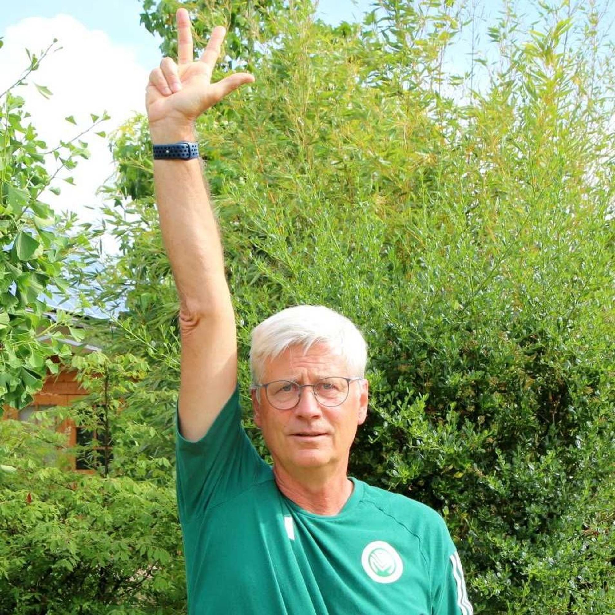 Uwe Stark hält einen Arm in die Höhe und zeigt mit den Fingern drei Sekunden an.