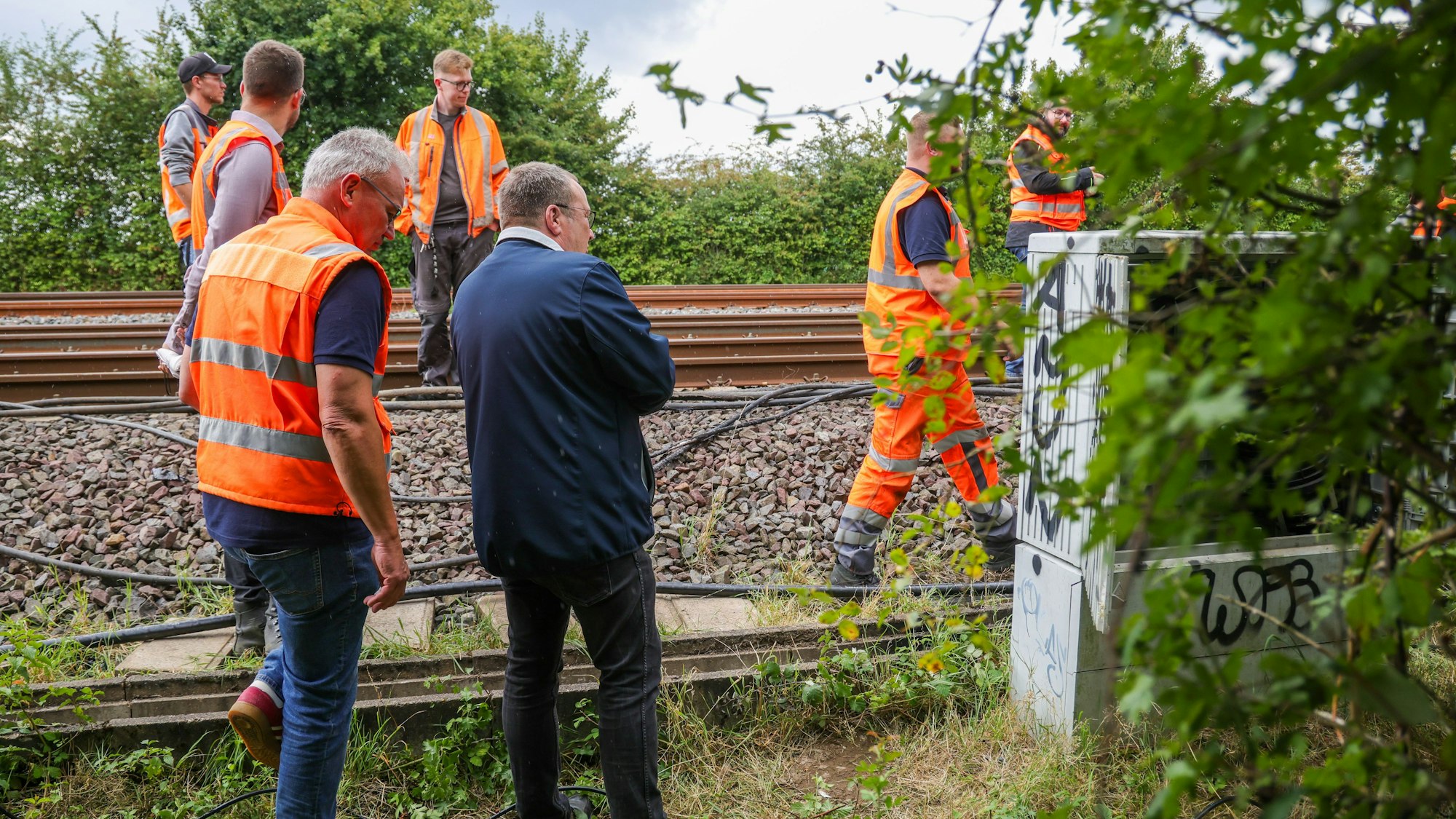 01.08.2025, Düsseldorf: Oliver Krischer (Bündnis 90/Grüne, M), Minister für Umwelt, Naturschutz und Verkehr des Landes Nordrhein-Westfalen, besucht den zweiten Tatort an der Bahnstrecke Duisburg-Düsseldorf. An der wichtigen Nord-Süd-Strecke der Bahn war am Morgen ein weiterer Brandsatz gezündet worden. Foto: Christoph Reichwein/dpa +++ dpa-Bildfunk +++