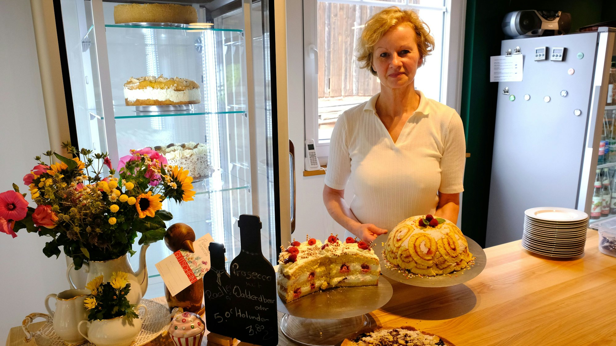 Sabine Pistl mit einer Auswahl ihrer Torten am Tresen ihres Cafés.