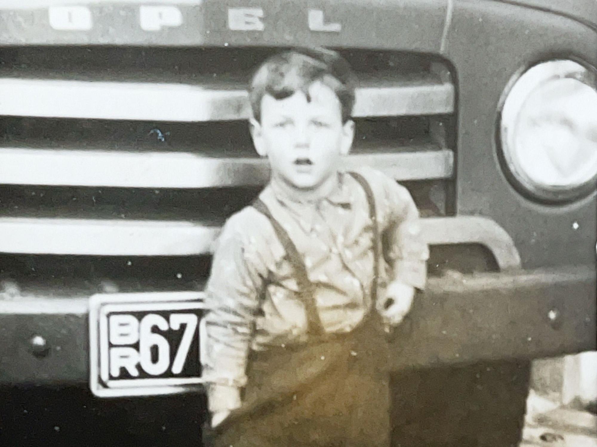 Der heutige Firmensenior Peter Offermann als Kind vor einem Lieferwagen.