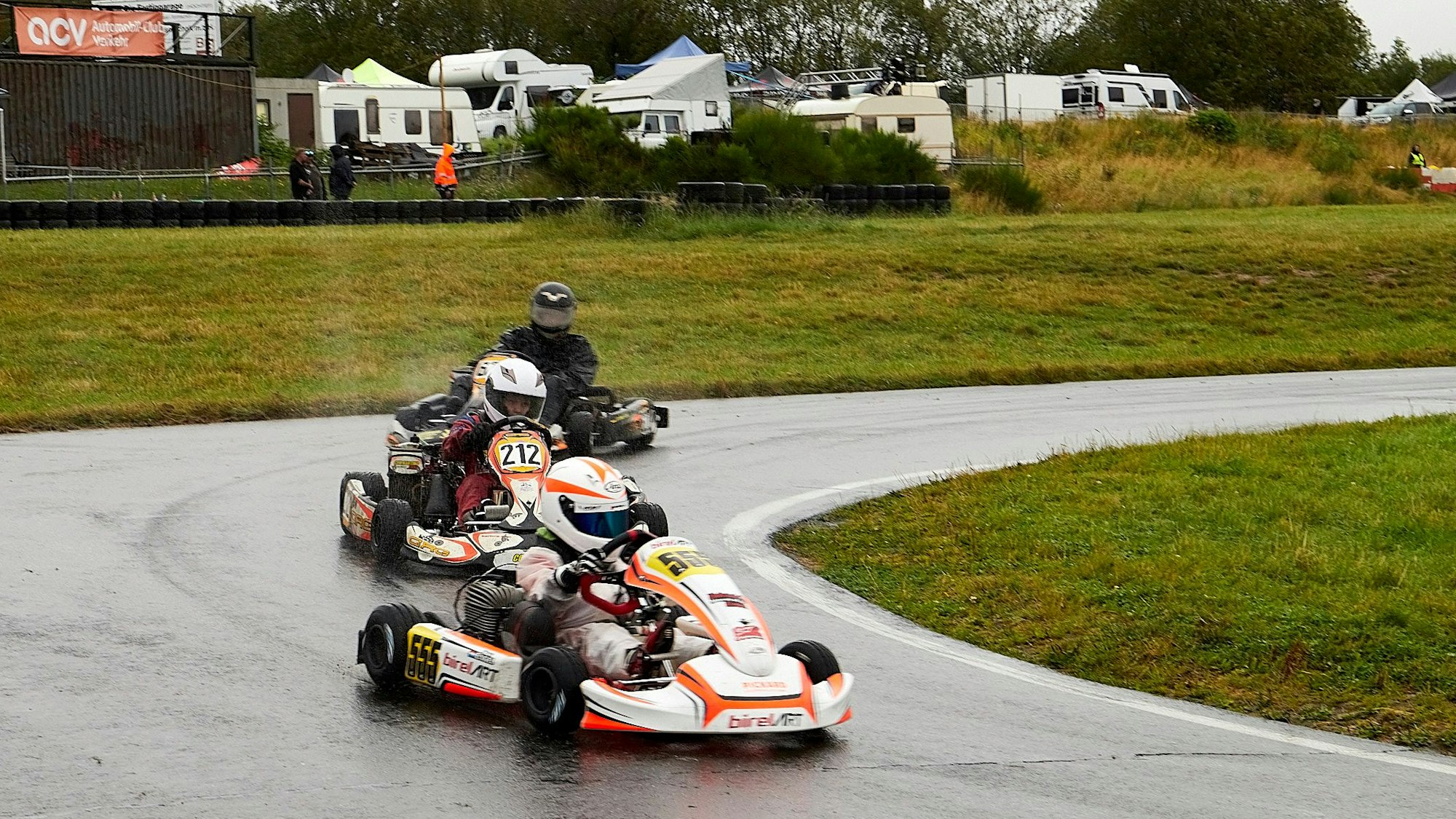 Drei Kartfahrer fahren bei einem Rennen auf der Dahlemer Binz.