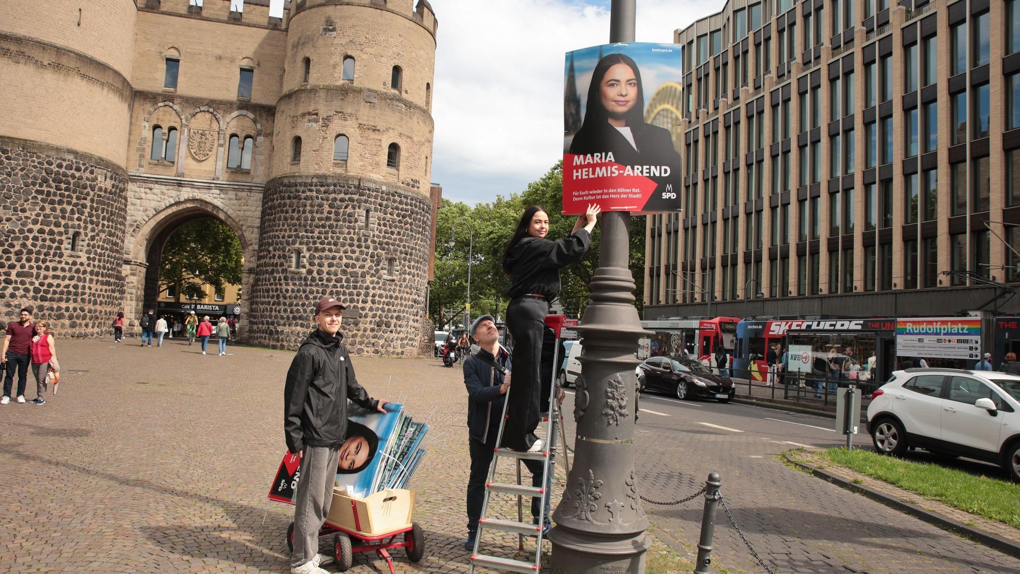 Maria Helmis-Arend (Kandidatin der SPD) plakatiert mit ihren Parteifreunden Marcus Cormann (hinten) und Niklas Behrendt-Emden (links).