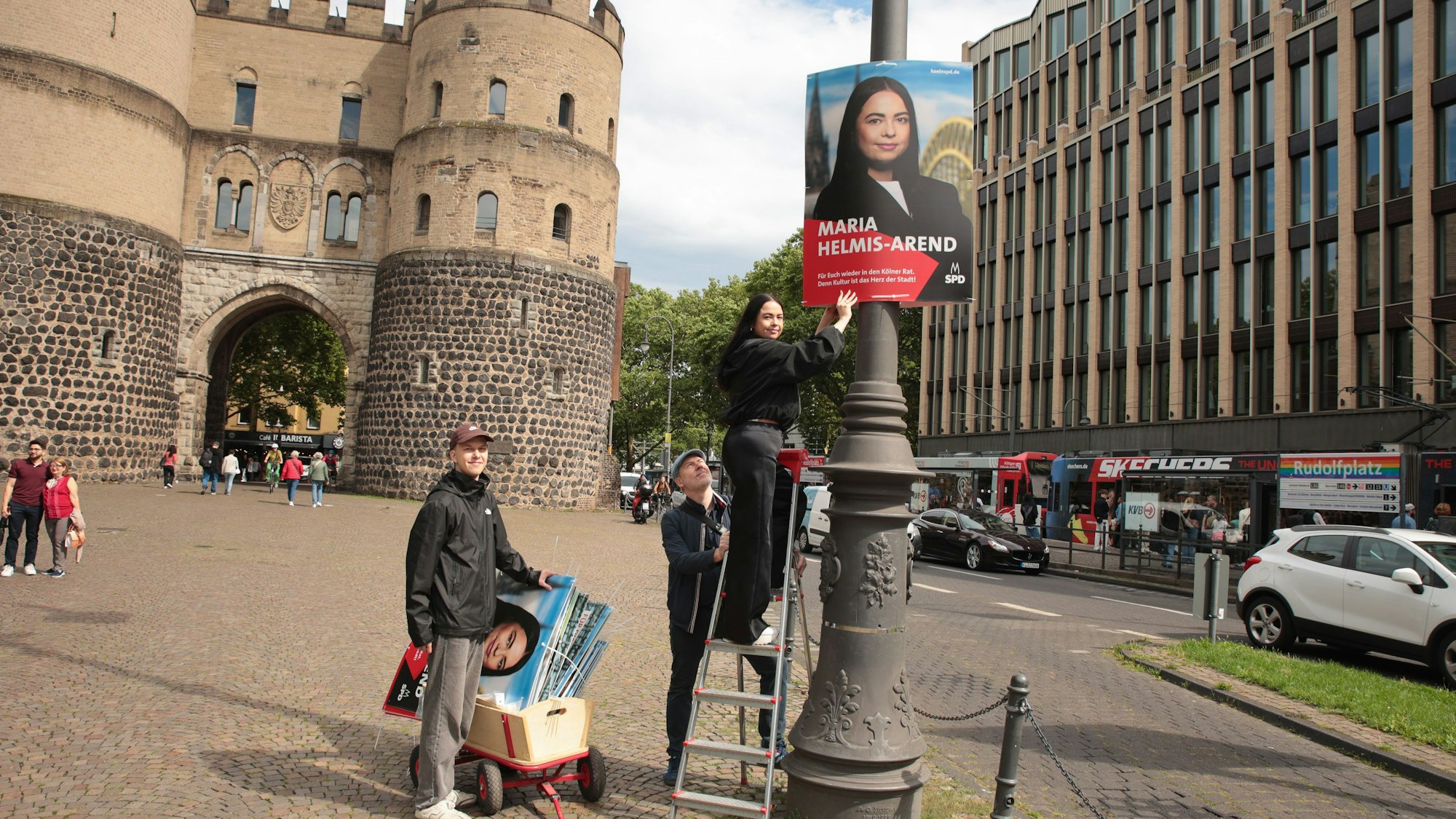 Maria Helmis-Arend (Kandidatin der SPD) plakatiert mit ihren Parteifreunden Marcus Cormann (hinten) und Niklas Behrendt-Emden (links).