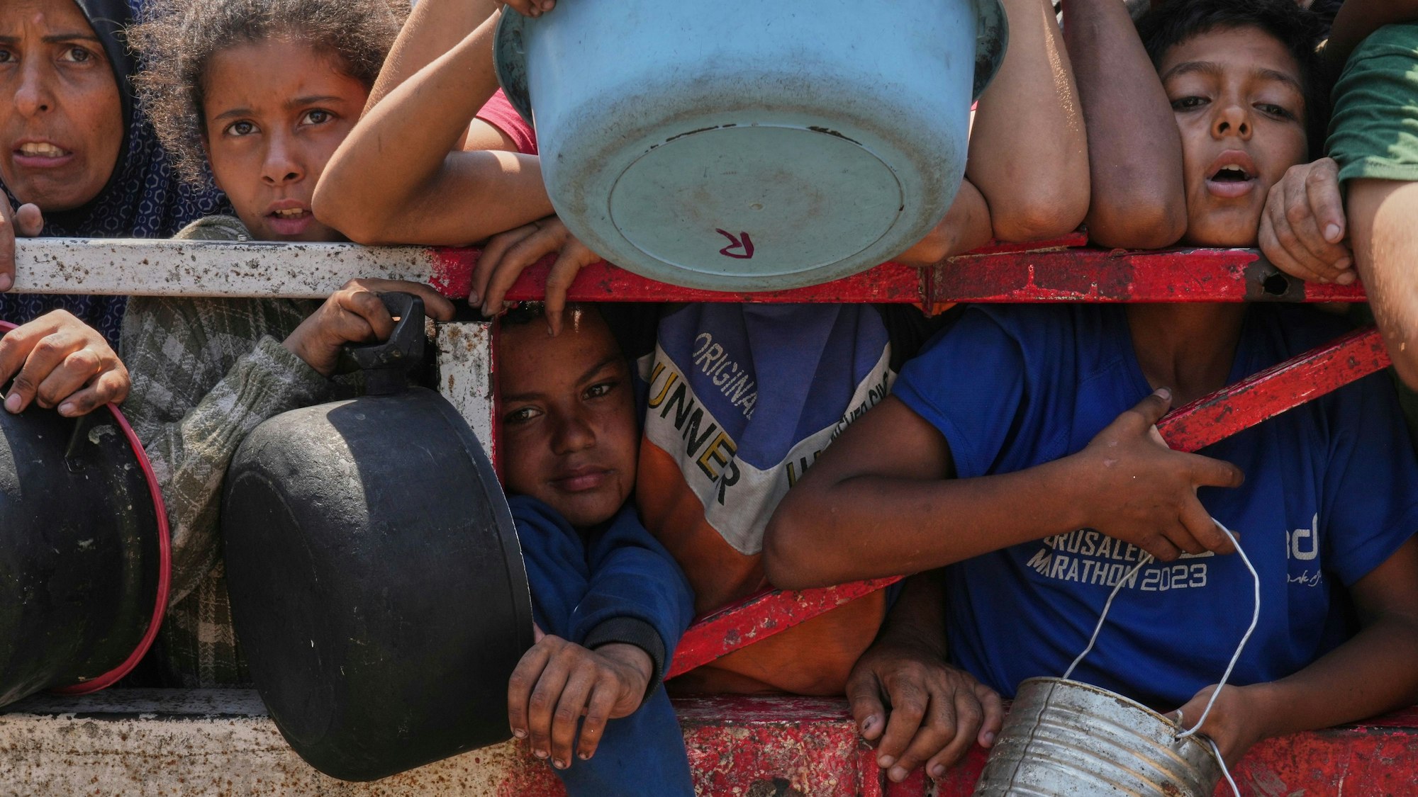 Kinder stehen dicht gedrängt mit leeren Schüsseln an einer Verteilstelle.