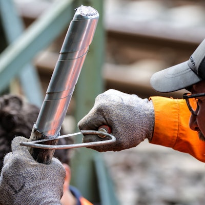 Ein Bahn-Mitarbeiter repariert ein dickes Kabel an der Stelle, wo im August ein Brandanschlag stattgefunden hat. An der wichtigen Nord-Süd-Strecke der Deutschen Bahn in Düsseldorf ist wenige Tage später noch ein zweiter Brandsatz gezündet worden.