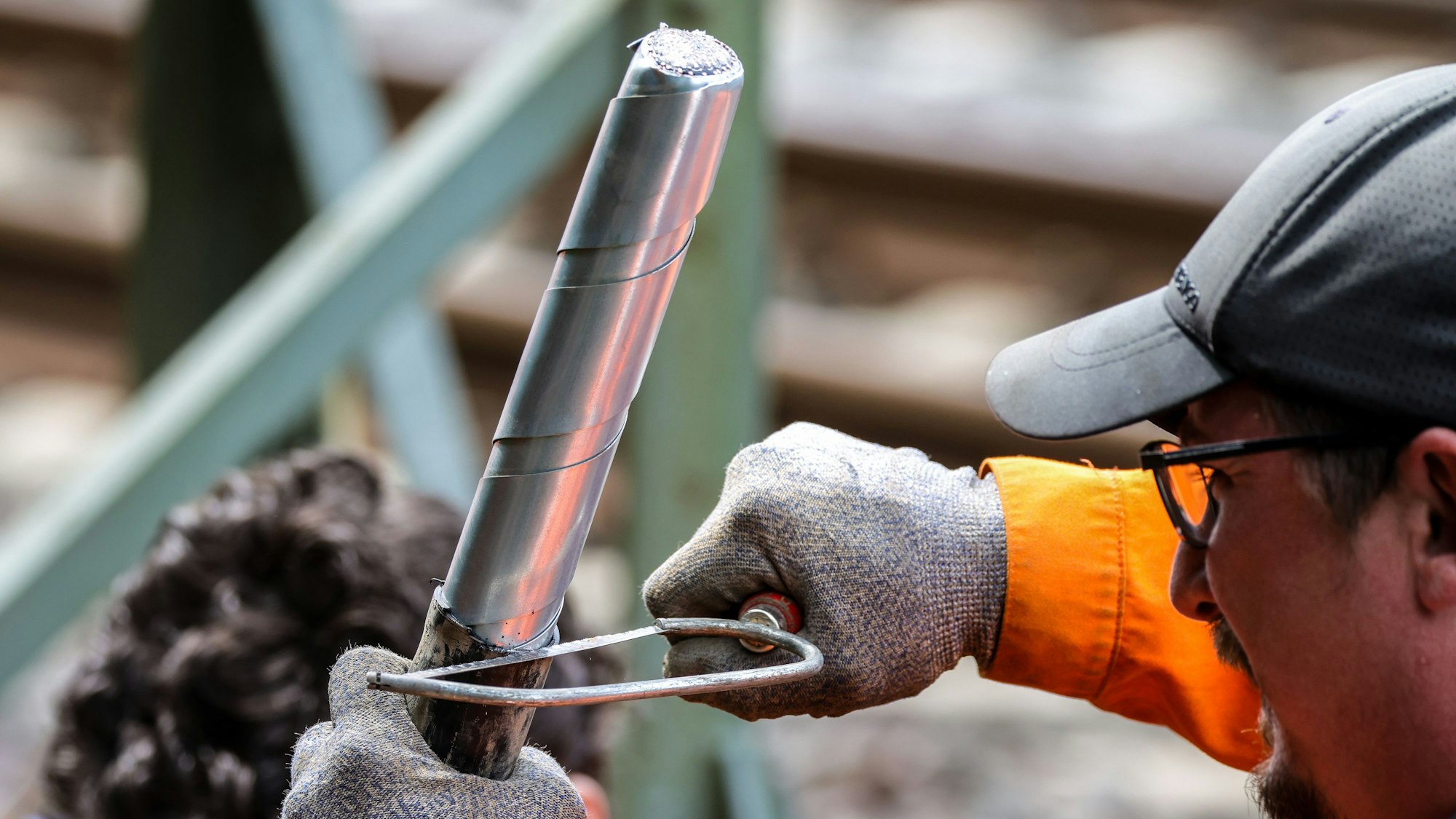 01.08.2025, Nordrhein-Westfalen, Düsseldorf: Ein Mitarbeiter der Deutschen Bahn repariert ein dickes Kabel an der Stelle, wo der zweite Brandanschlag festgestellt wurde. An der wichtigen Nord-Süd-Strecke der Deutschen Bahn ist in Düsseldorf ein weiterer Brandsatz gezündet worden. Der Brandsatz habe die gleiche Machart wie der am Donnerstag entdeckte, es sei ebenfalls Schaden entstanden. Foto: Christoph Reichwein/dpa +++ dpa-Bildfunk +++