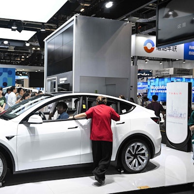 People visit a Tesla stand during the World Artificial Intelligence Conference (WAIC) at the Shanghai World Expo and Convention Center in Shanghai on July 28, 2025. (Photo by Hector RETAMAL / AFP)