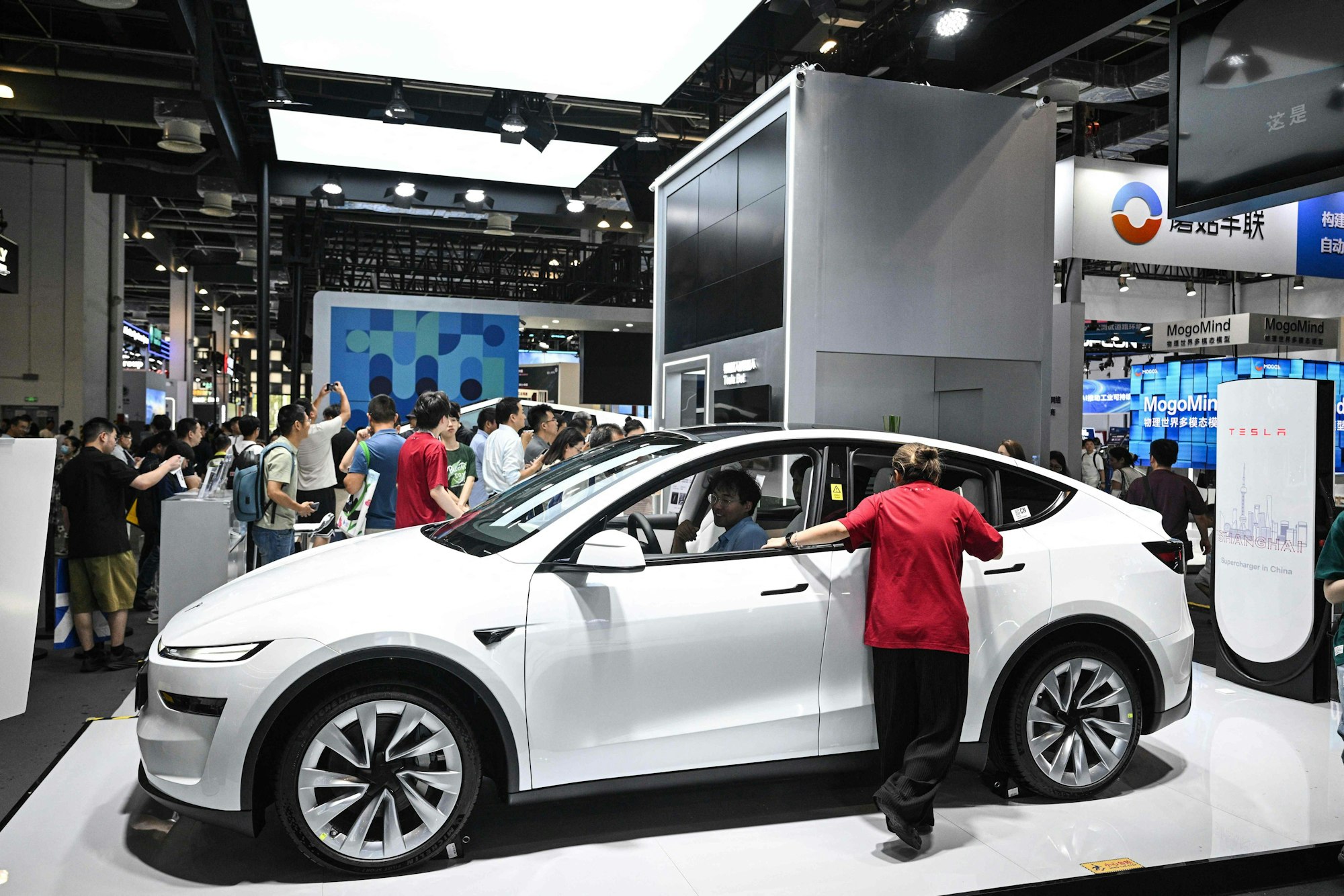 People visit a Tesla stand during the World Artificial Intelligence Conference (WAIC) at the Shanghai World Expo and Convention Center in Shanghai on July 28, 2025. (Photo by Hector RETAMAL / AFP)