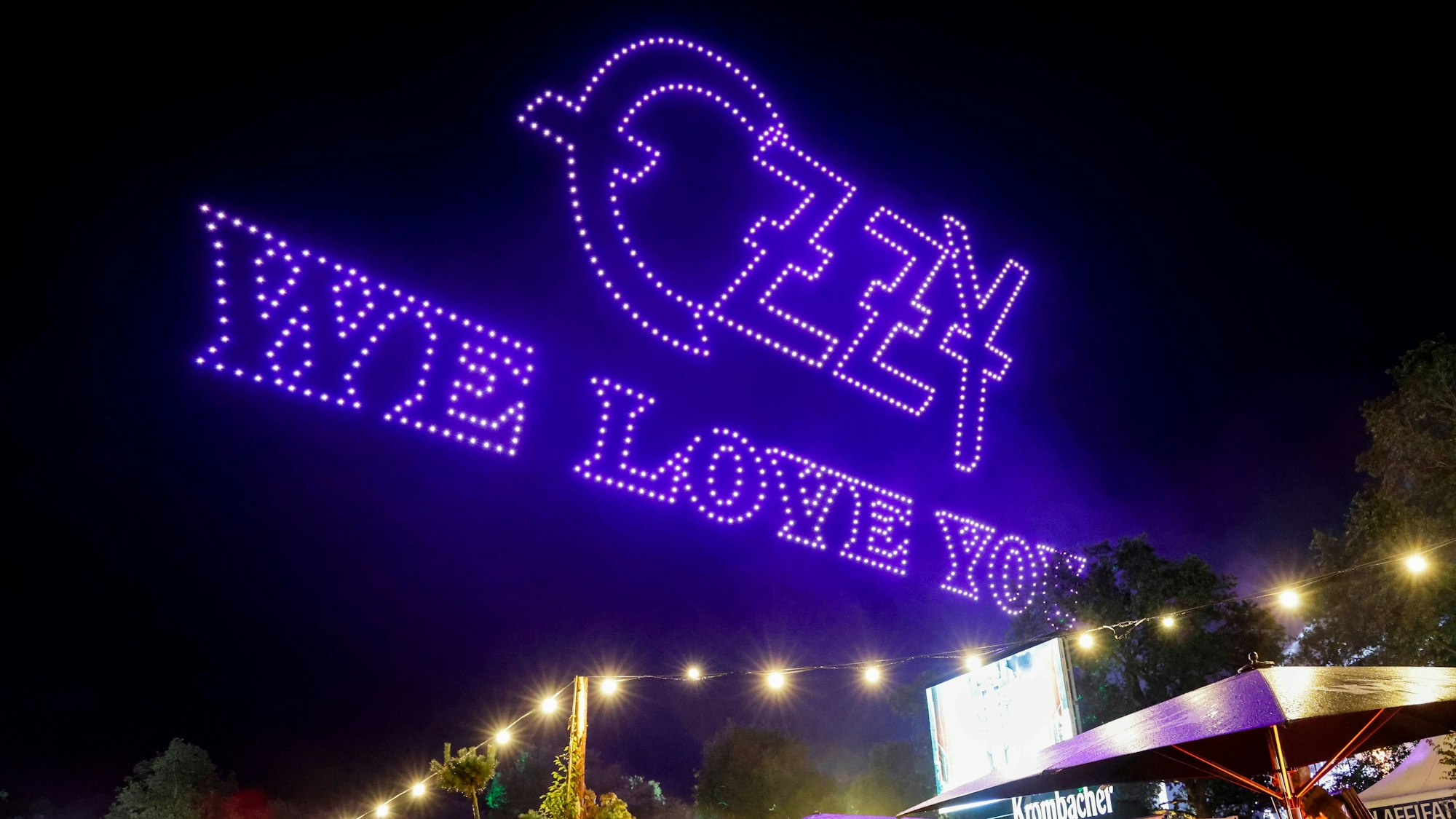 02.08.2025, Schleswig-Holstein, Wacken: Drohnen bilden den Schriftzug «Ozzy we love you« am Himmel über dem Festivalgelände beim Wacken Open Air. Damit wurde der verstorbenen Heavy-Metal-Legende Ozzy Osbourne gedacht. Das Wacken Open Air (WOA) findet vom 30. Juli bis 2. August statt und gilt als größtes Heavy-Metal-Festival der Welt. Foto: Frank Molter/dpa +++ dpa-Bildfunk +++