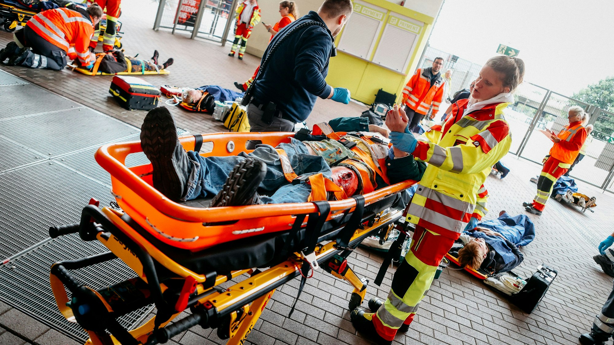 Menschen werden auf Tragen versorgt.