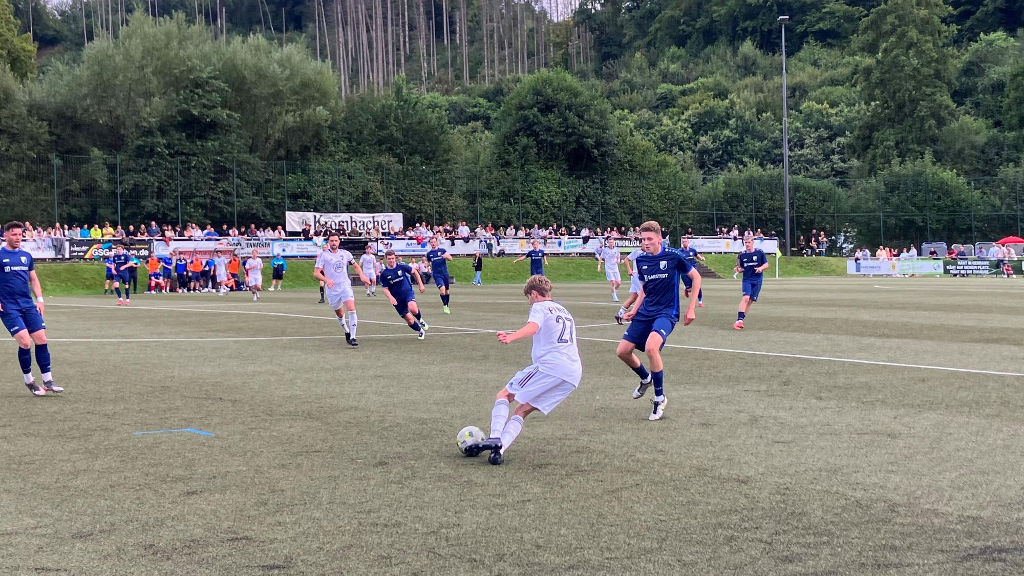 Eine Spielsituation zwischen zwei Teams sauf einem Fußballplatz.