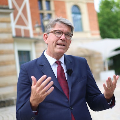 Das Bild zeigt Wolfram Weimer, Staatsminister für Kultur und Medien, der vor dem Bayreuther Festspielhaus steht. Foto: Karl-Josef Hildenbrand/dpa