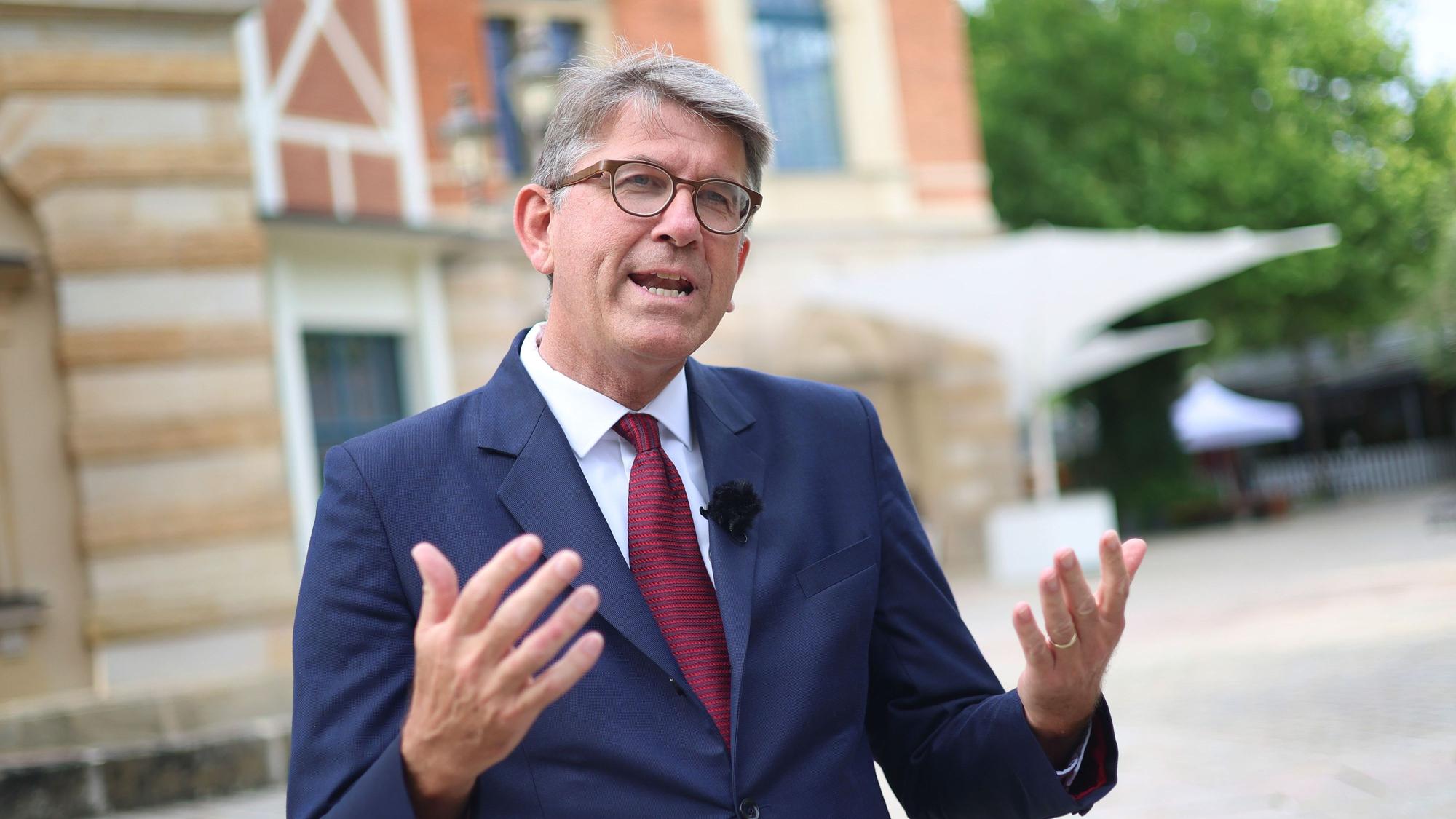 Das Bild zeigt Wolfram Weimer, Staatsminister für Kultur und Medien, der vor dem Bayreuther Festspielhaus steht. Foto: Karl-Josef Hildenbrand/dpa