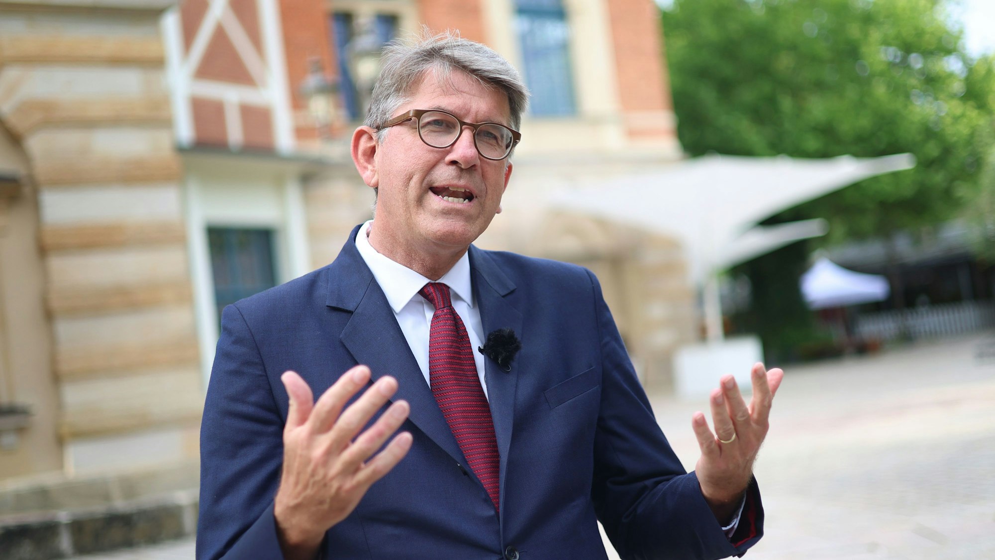Das Bild zeigt Wolfram Weimer, Staatsminister für Kultur und Medien, der vor dem Bayreuther Festspielhaus steht. Foto: Karl-Josef Hildenbrand/dpa