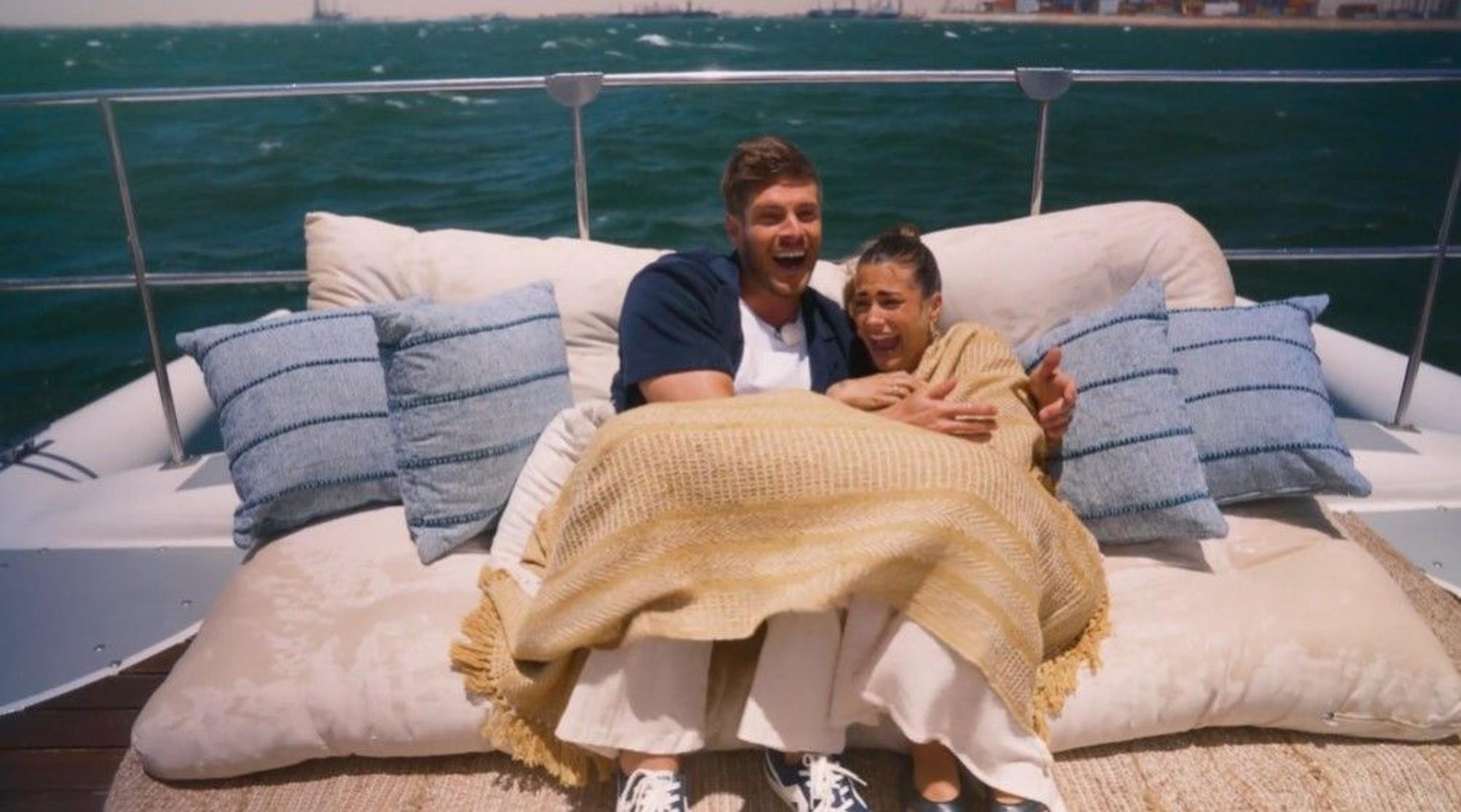Der Troisdorfer Martin Braun liegt unter einer Kuscheldecke auf einem Katamaran mit Kandidatin Lena. Beide lachen.