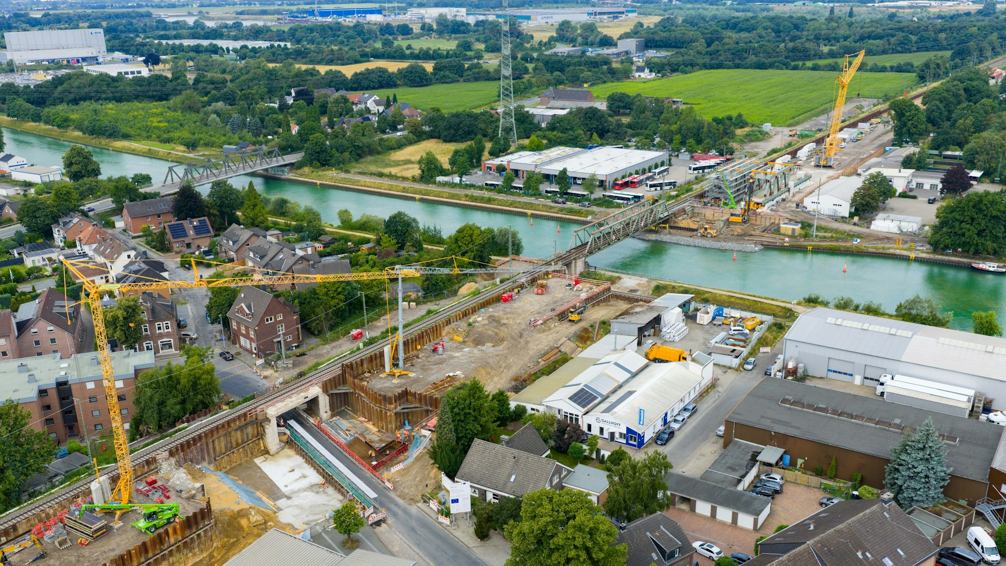 22.07.2025, Nordrhein-Westfalen, Voerde: Kräne und Baufahrzeuge an der Bahn-Baustelle im Bereich Bahnhof Voerde. (Luftbild mit einer Drohne) Die rund 73 Kilometer lange Strecke von Oberhausen nach Emmerich ist ein Teilstück des europäischen Güterverkehrskorridors vom Nordseehafen Rotterdam bis nach Genua am Mittelmeer. Seit November 2024 ist die Strecke wegen der Bauarbeiten 80 Wochen lang gar nicht oder nur eingeschränkt befahrbar. Foto: Christoph Reichwein/dpa +++ dpa-Bildfunk +++