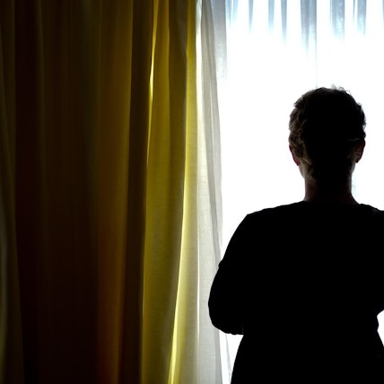 Das Bild zeigt eine junge Frau in einem Zimmer eines Frauenhauses.Foto: Peter Steffen/dpa